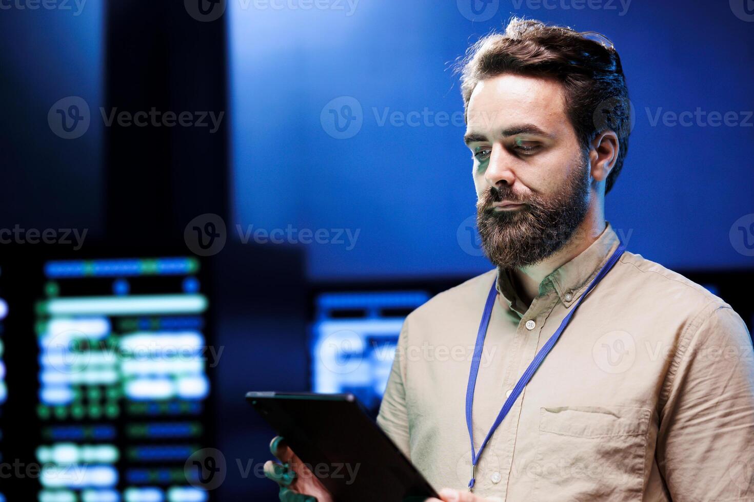 Experienced serviceman walking in high tech facility supporting AI through high performance computing. IT expert making sure server hub electronics are functioning properly photo