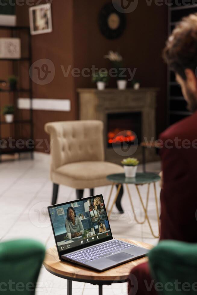 White collar worker on videocall in lobby, attending business conference online in lounge area at luxury hotel. Entrepreneur using laptop to chat on teleconference, waiting for check in. photo
