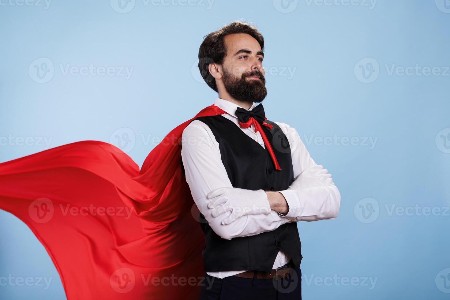 Person wearing red cape and formal suit posing with confidence, feeling determined to help and save people. Young man pretending to be fantasy cartoon superhero with mantle, superhuman. photo