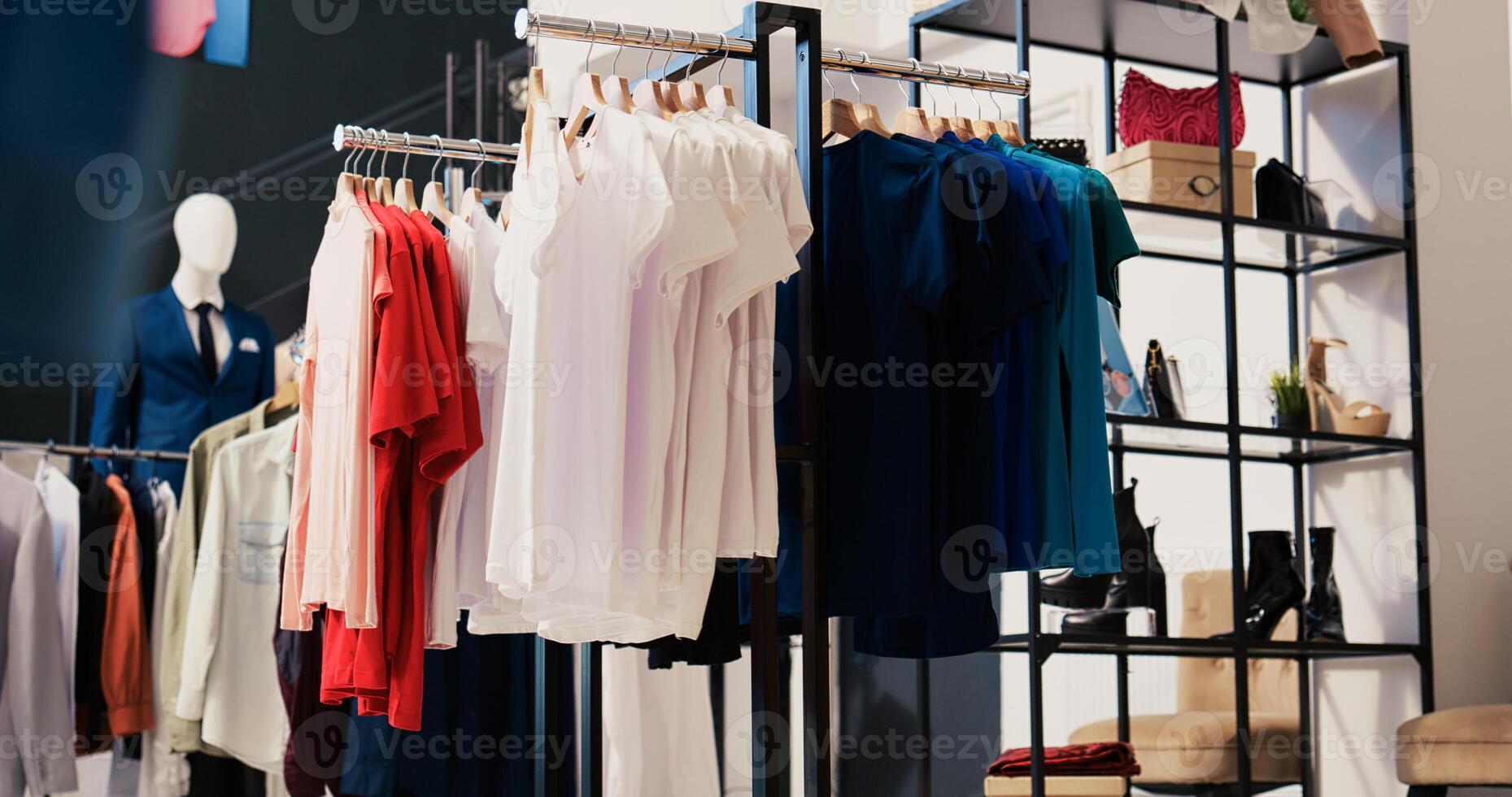 Modern boutique filled with casual wear, multiple racks with fashionable merchandise. Interior of empty clothing store with new fashion colletion on hangers. Small business concept. photo