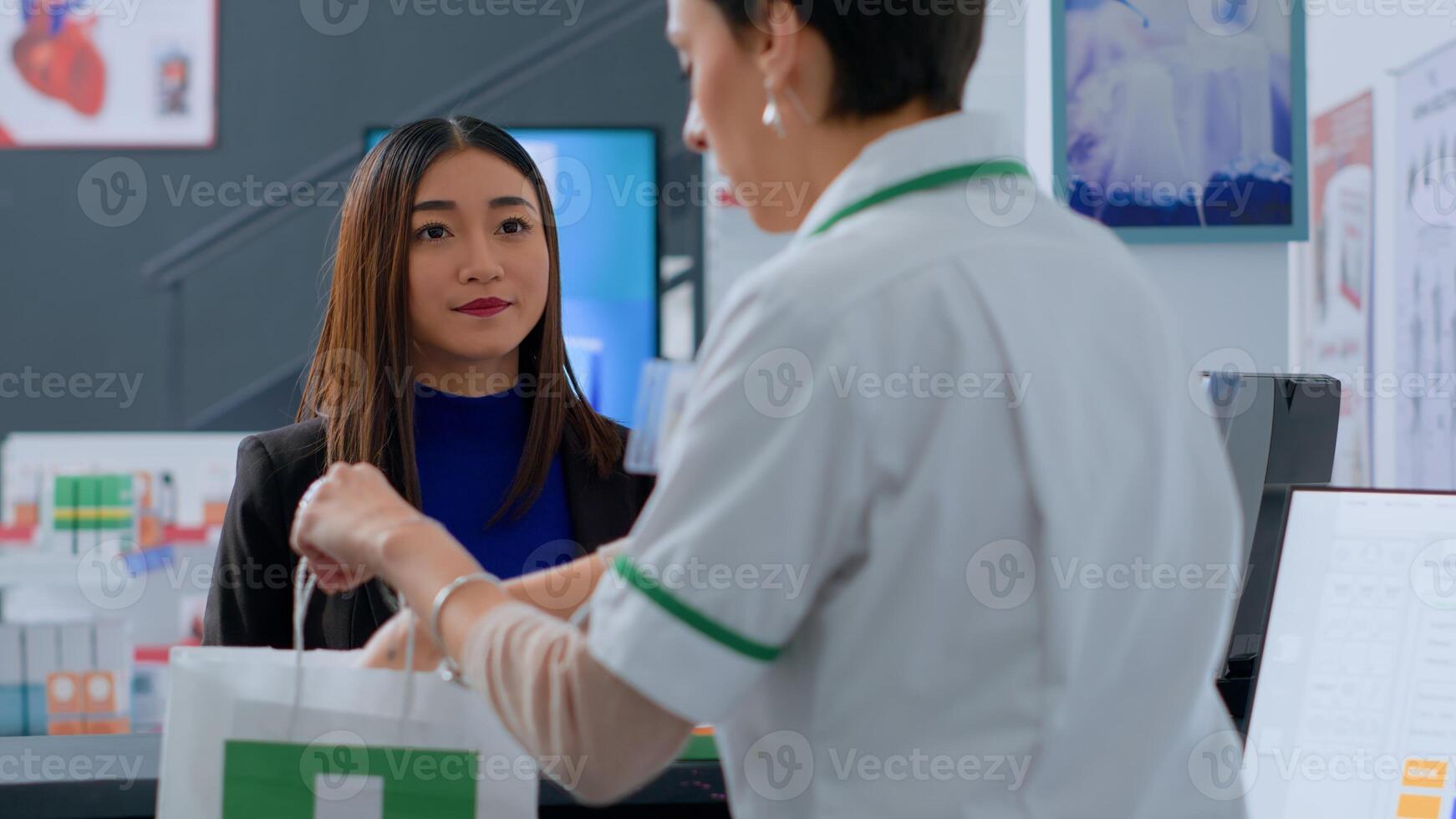 Senior pharmacy assistant helping asian client pick ideal medicinal products for ameliorating pain before reaching drugstore counter. Customer purchasing wellness supplements and vitamins photo