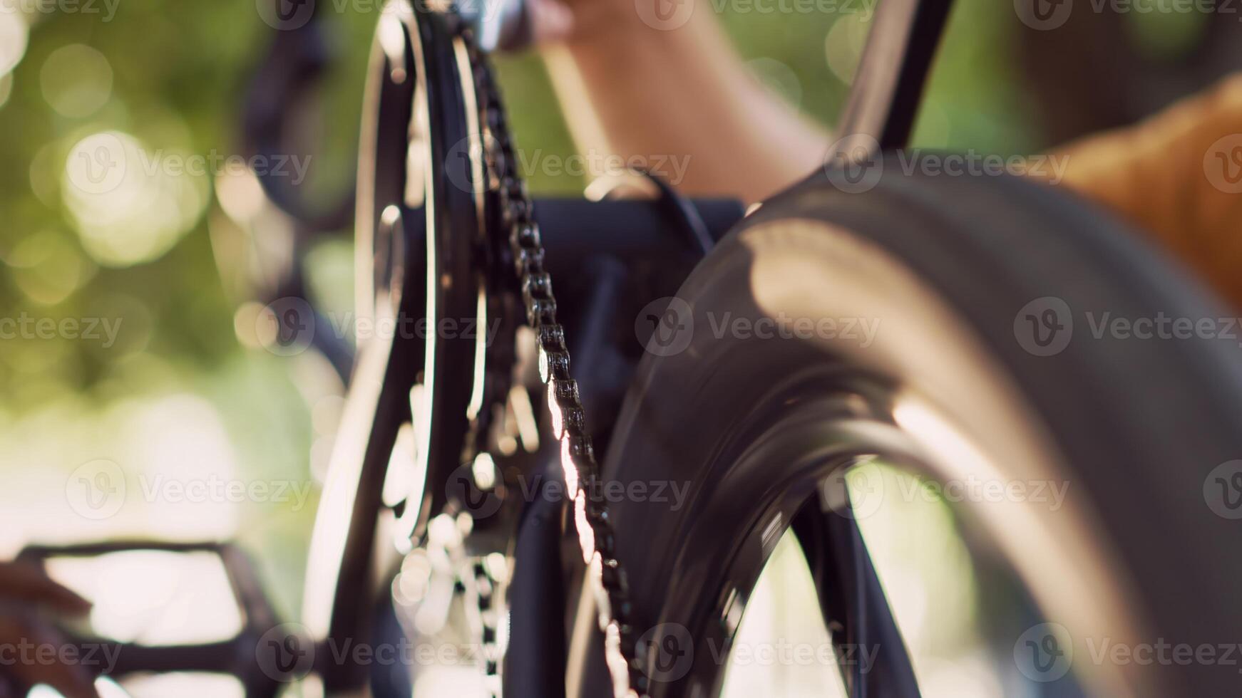 Close-up shot of two persons greasing chain of modern bicycle in home yard. Detailed view of caucasian boyfriend applying grease to bike components with the help african american girlfriend outdoor. photo