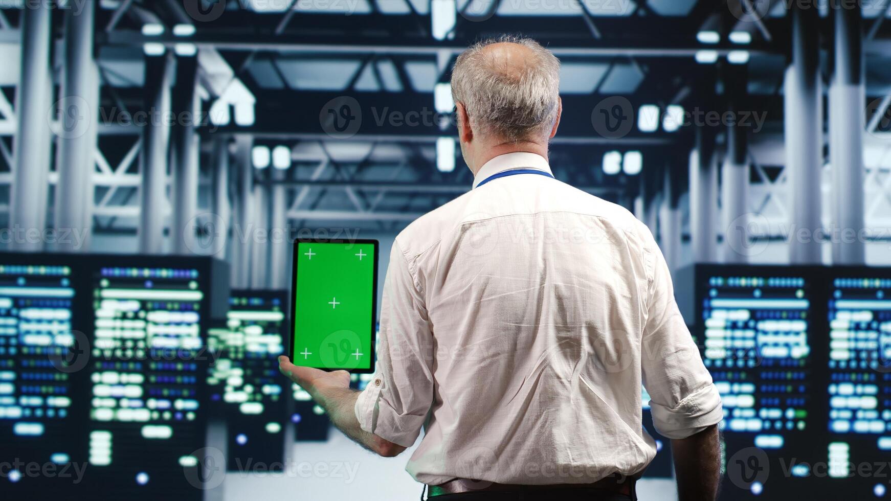 Tech savvy specialist expertly managing data while navigating through industrial supercomputers. Expert ensuring flawless cybersecurity shielding, optimizing systems using green screen tablet photo
