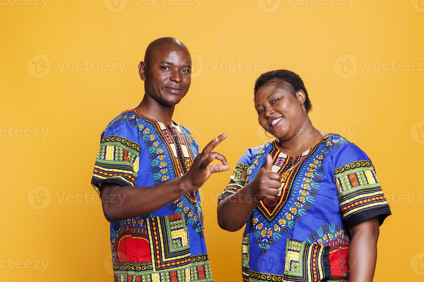 Smiling cheerful couple showing thumb up and ok symbol gesture portrait. Man and woman showcasing approval sign, giving positive feedback and looking at camera with carefree expression photo