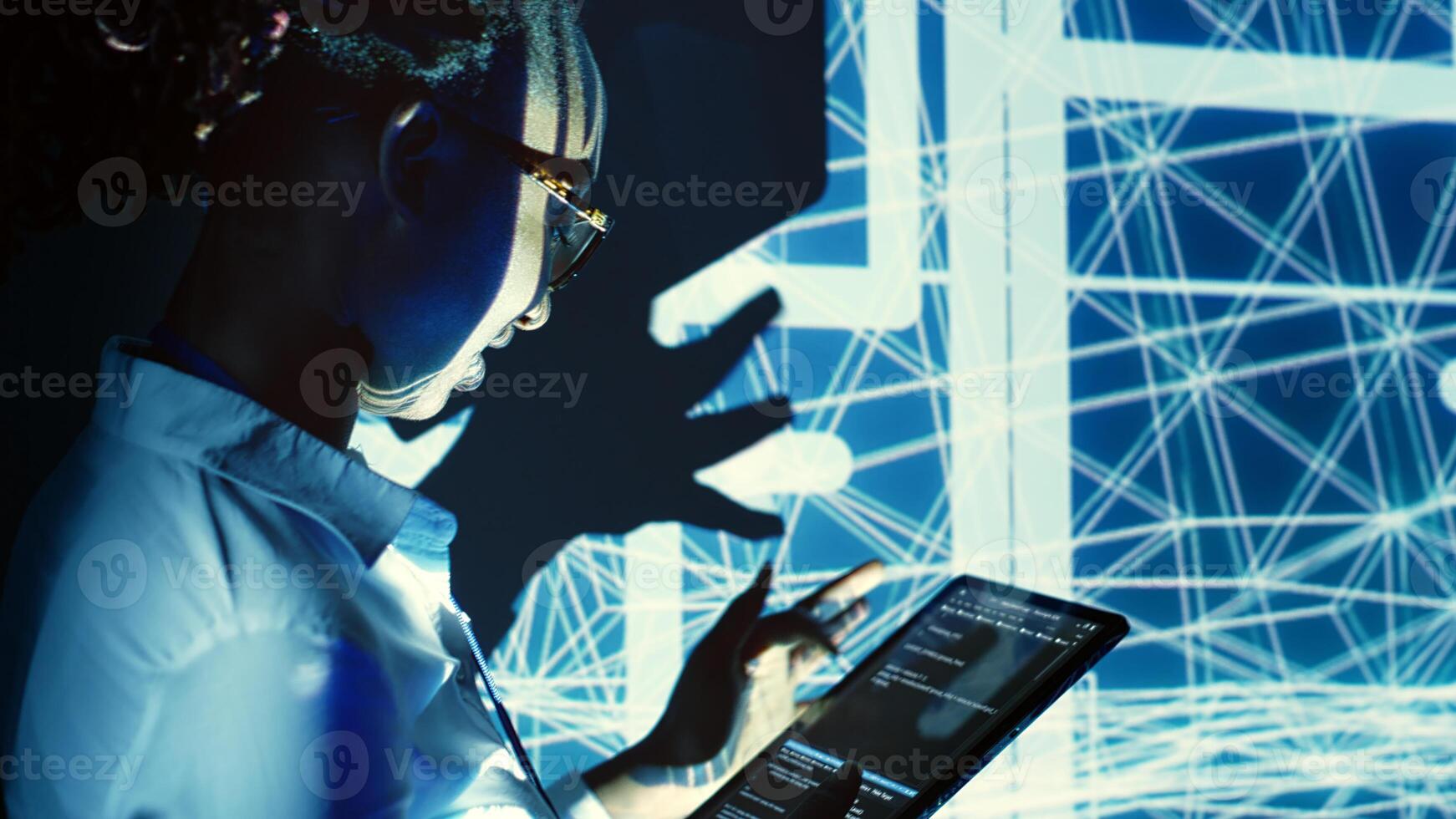 Capable supervisor overseeing dimly lit server hub, running code on tablet, doing checkup on technologically advanced machines clusters made of servers, networking systems and storage arrays photo