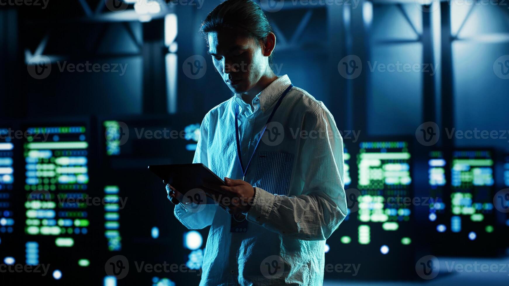 Asian man strolling through data center server rows providing processing and memory resources for different workloads. Engineer monitoring supercomputers tasked with solving complex operations photo