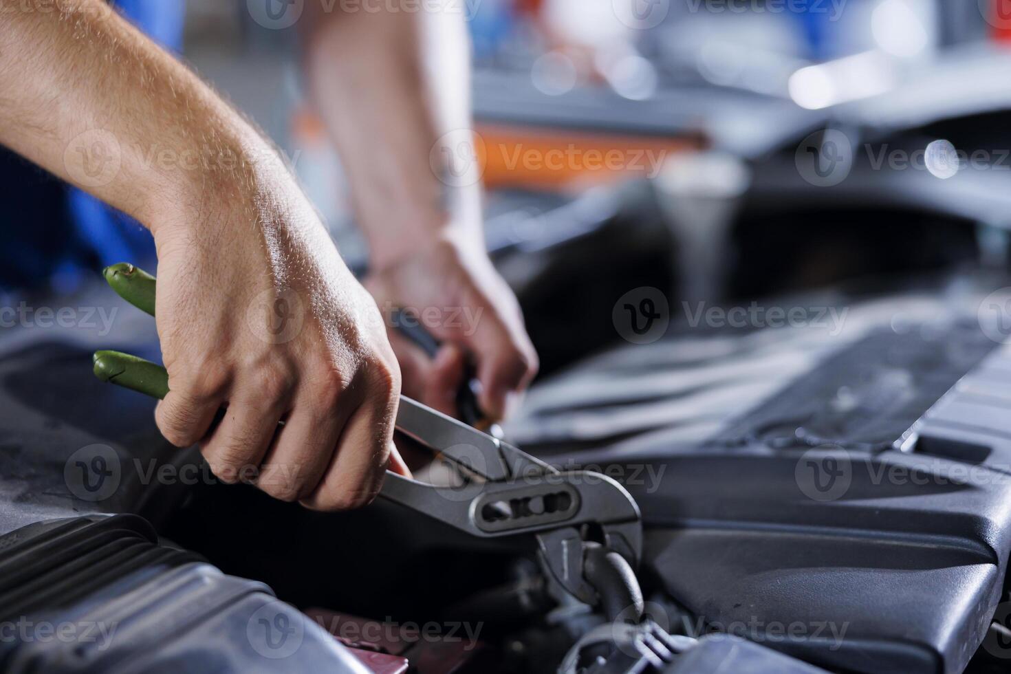 Car service technician expertly examines engine using advanced mechanical tools, ensuring ideal automotive performance and safety. Meticulous garage expert conducts routine vehicle checkup with pliers photo