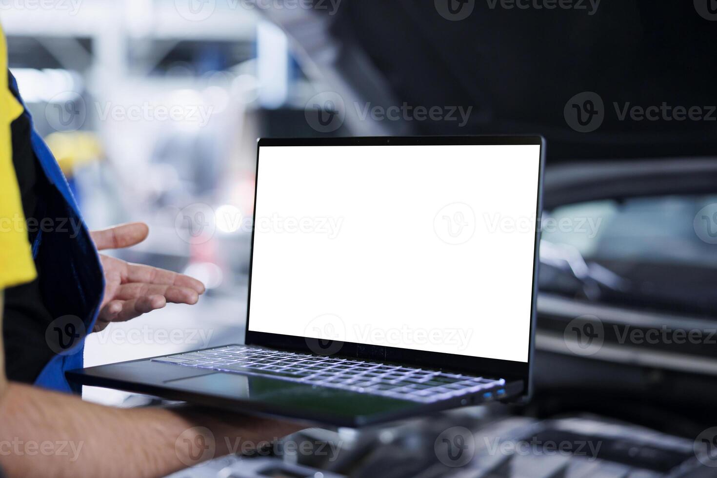 Trained repairman in garage using mockup laptop to follow checklist while doing maintenance on customer car. Precise specialist in repair shop does checkup on client vehicle helped by isolated screen device photo