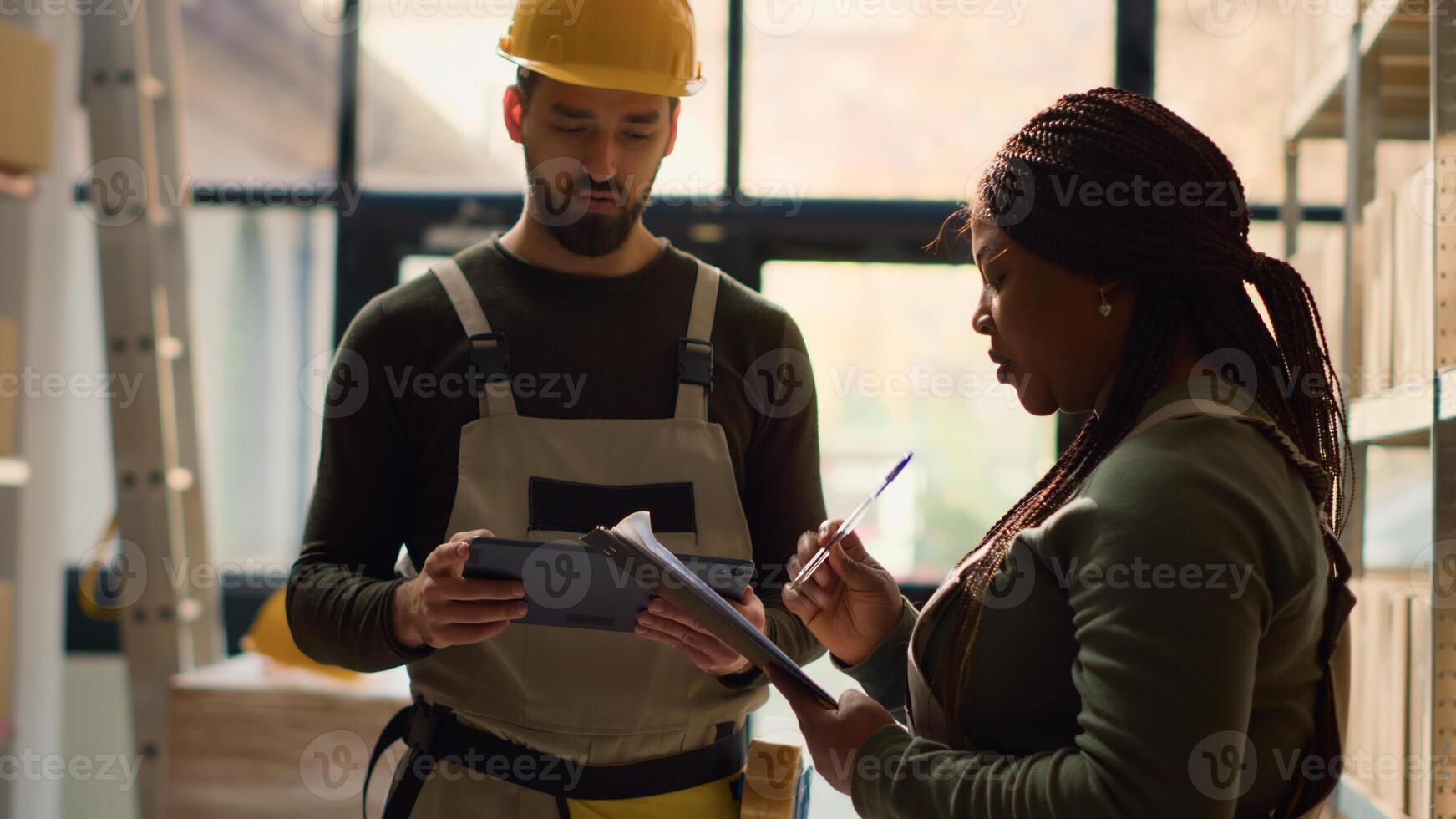 Teamworking colleagues performing warehouse inventory controls, keeping quality standards high. Qualified experts in storage room preparing to ship parcels to customers, crosschecking delivery info photo