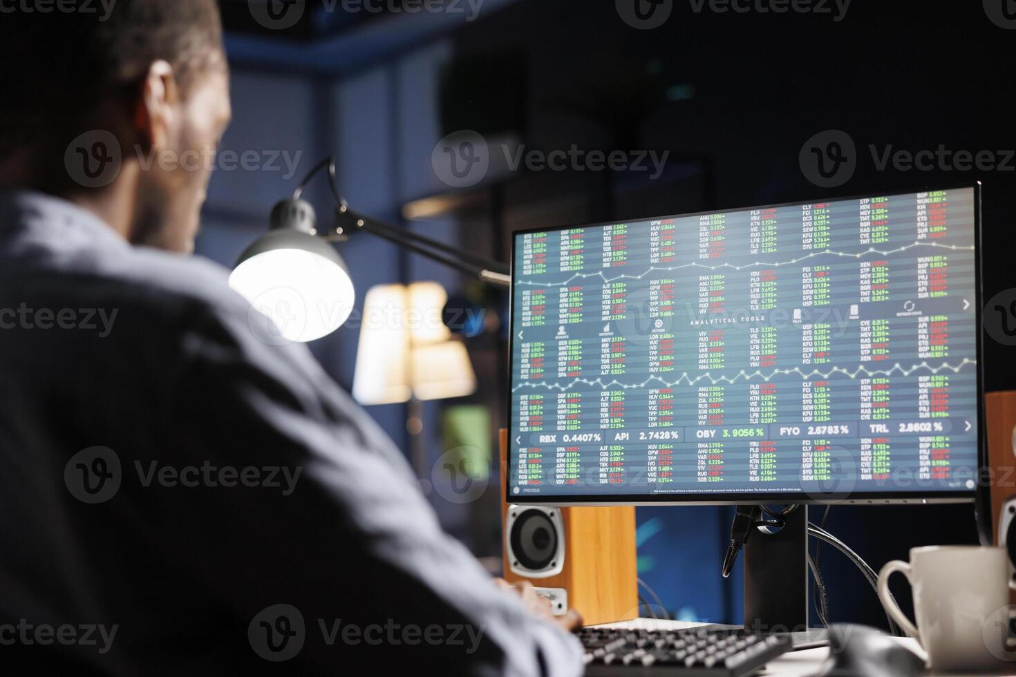 Trader monitors stock market real time changes on computer, investing funds with the goal to boost company earnings. African american guy studying economic values for global advancement. photo