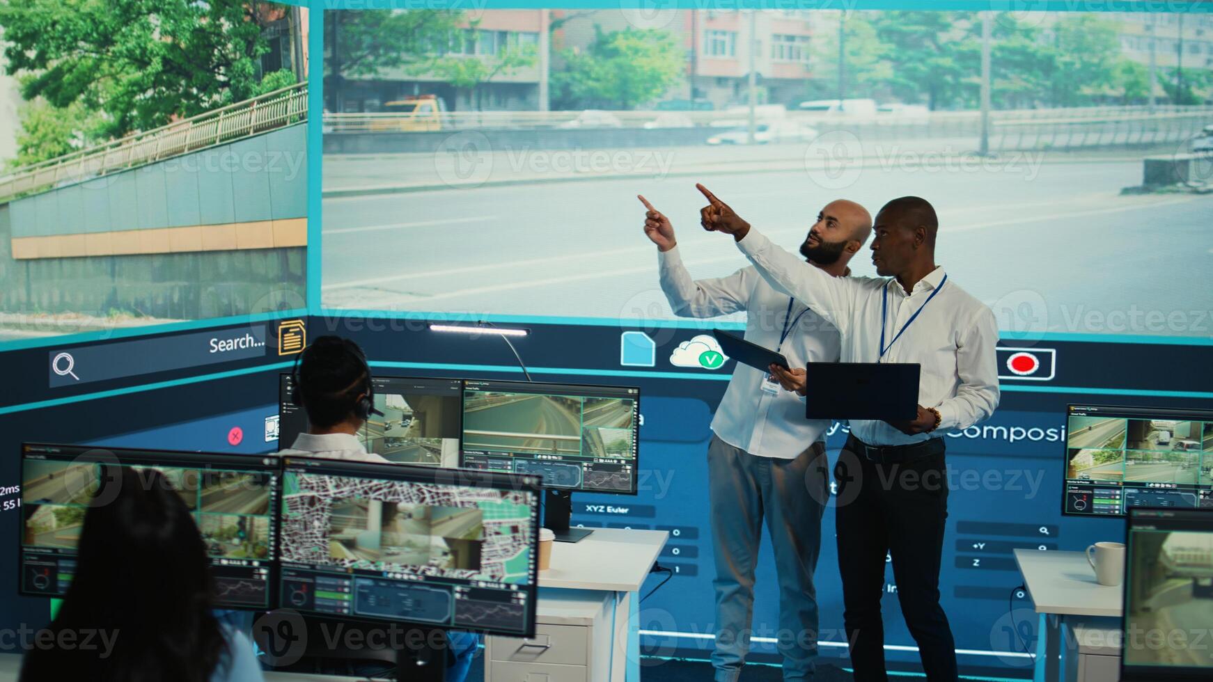 Diverse employees using CCTV surveillance system in monitoring traffic, tracking speed limits for public safety via satellite radar system. People operating on a big screen in control center. Camera B. photo