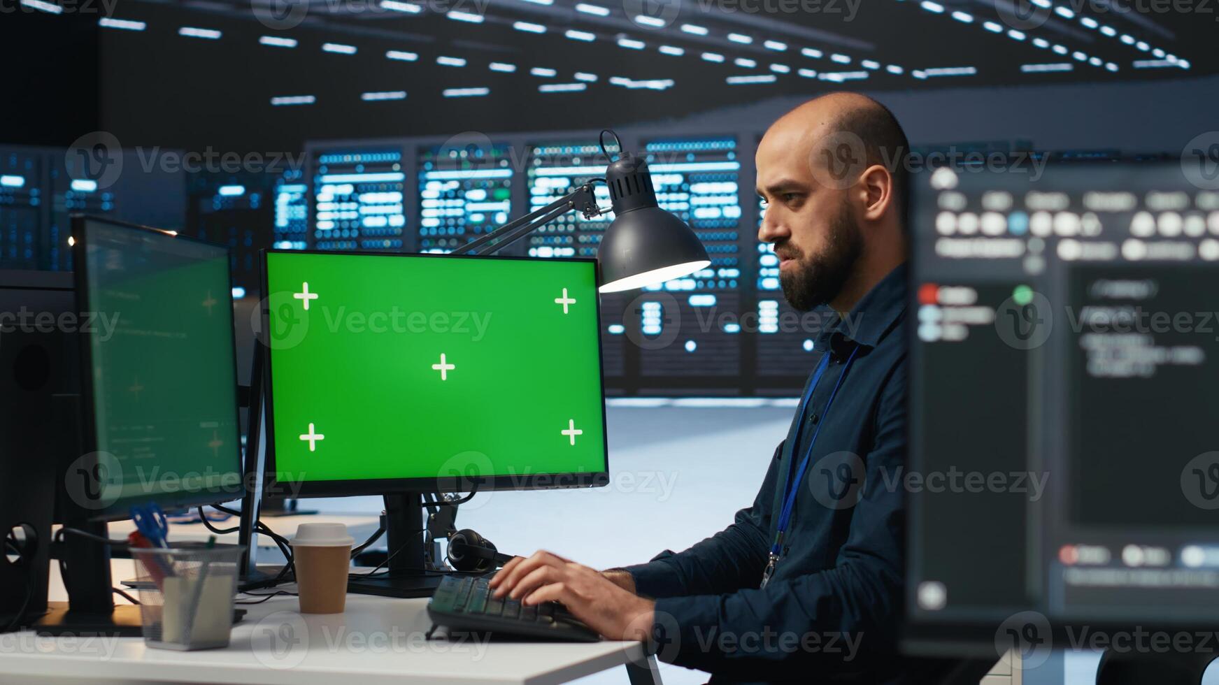 Technician overseeing server room, running code on green screen computer, troubleshooting servers. Software developer upgrading hardware clusters and storage arrays using mockup PC monitor photo