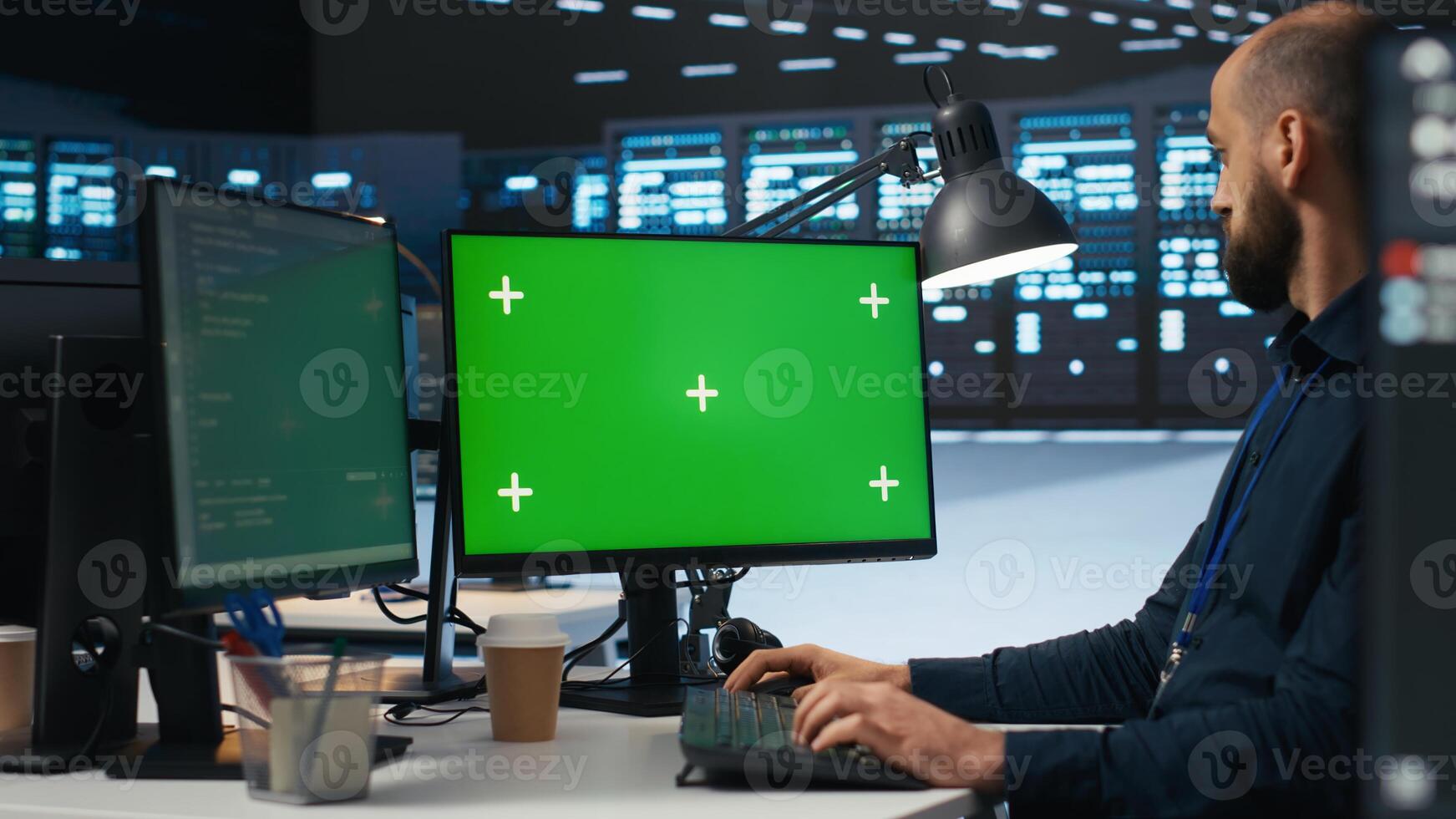 IT employee programming on green screen PC in data center housing supercomputers storing datasets. Admin writing code on mockup computer monitor to mend data center racks photo