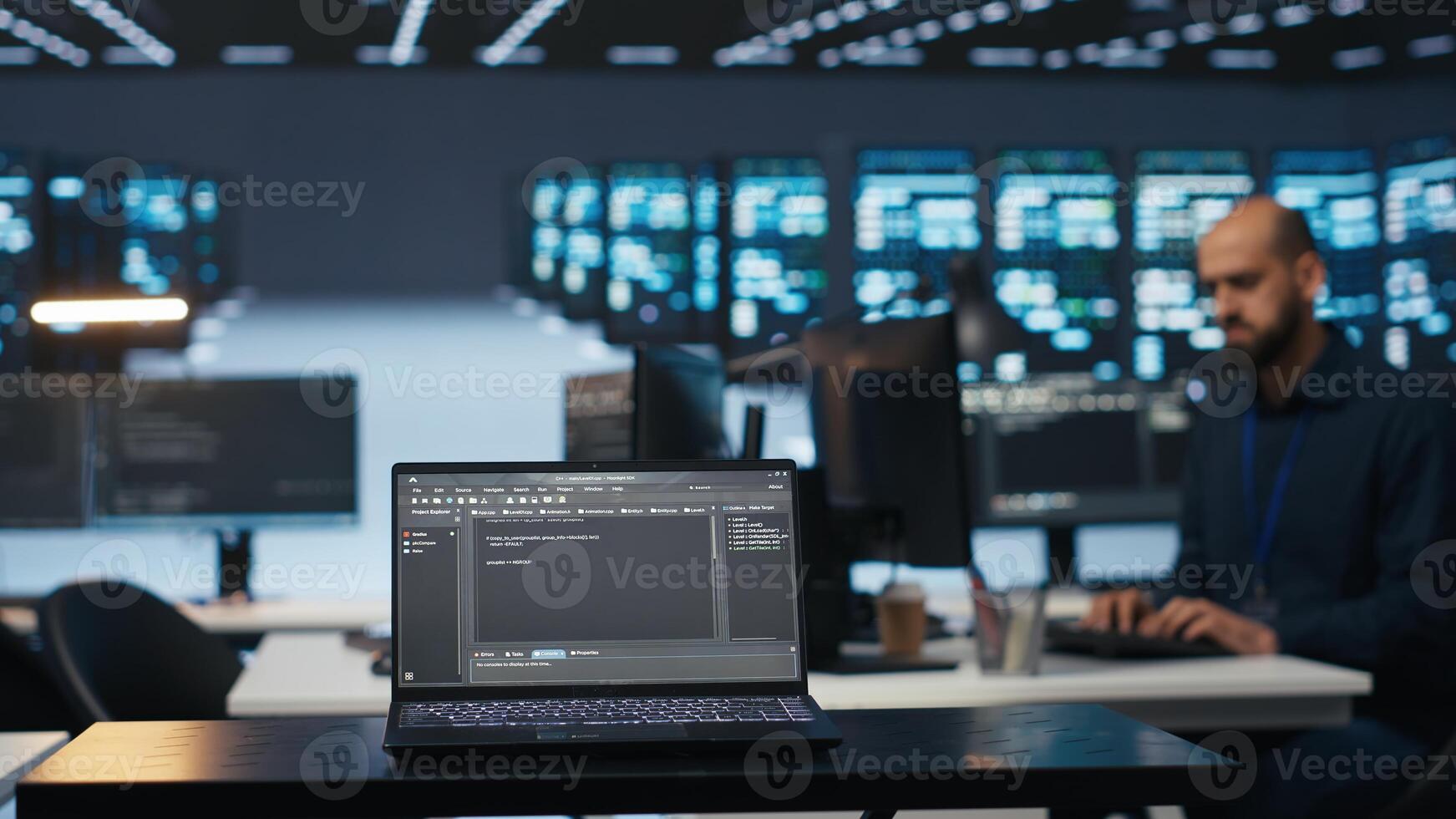 Focus on laptop used by programmer running code in blurry background for data center servers, troubleshooting rigs. Close up shot of code lines on notebook screen in server hub photo