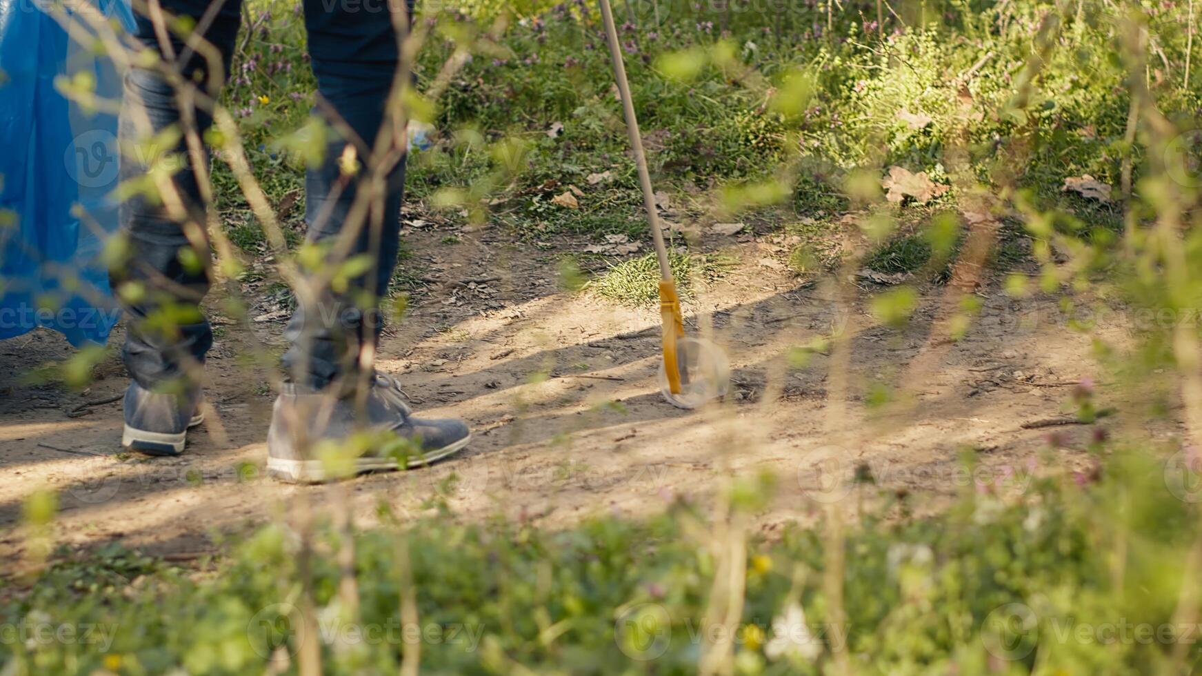 Diverse people working as activists to clean the forest from junk, fighting illegal dumping to protect the natural environment. Volunteers collecting rubbish, using tools to grab trash. Camera A. photo