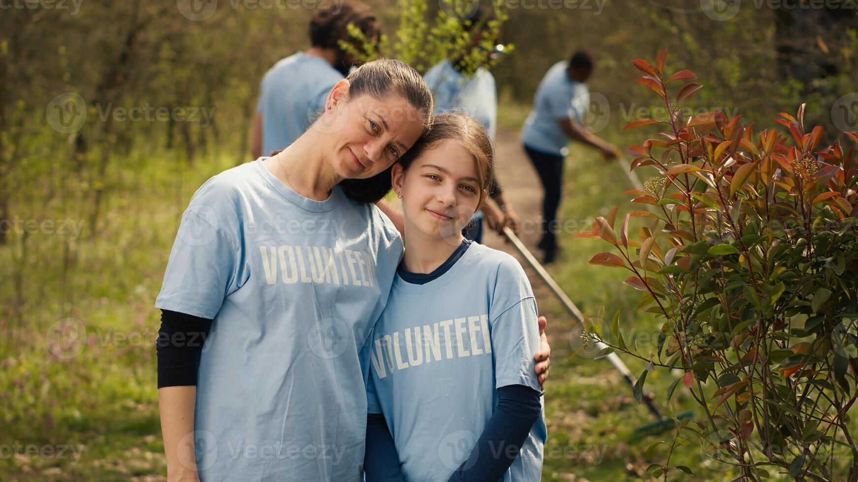 Portrait of mother and daughter volunteering to clean up a forest area, showing a sense of devotion and responsibility for the natural environment conservation. Ecological justice. Camera A. photo