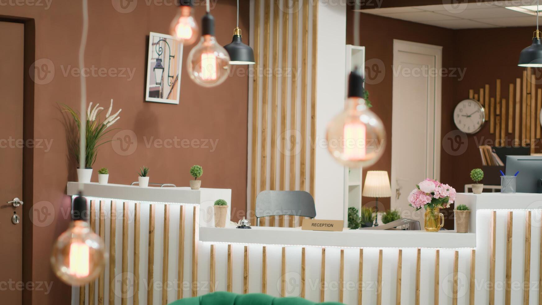Elegant hotel reception counter used for guests registration and lounge area decorated with green armchairs. Empty lobby front desk space with stylish furniture ready to welcome travellers. photo