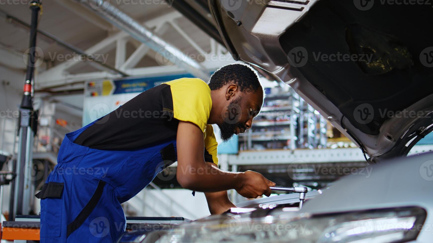 Meticulous specialist in car service picks torque wrench from work station bench, using it to tighten screws after replacing engine. Professional in garage fixing client automobile, close up shot photo