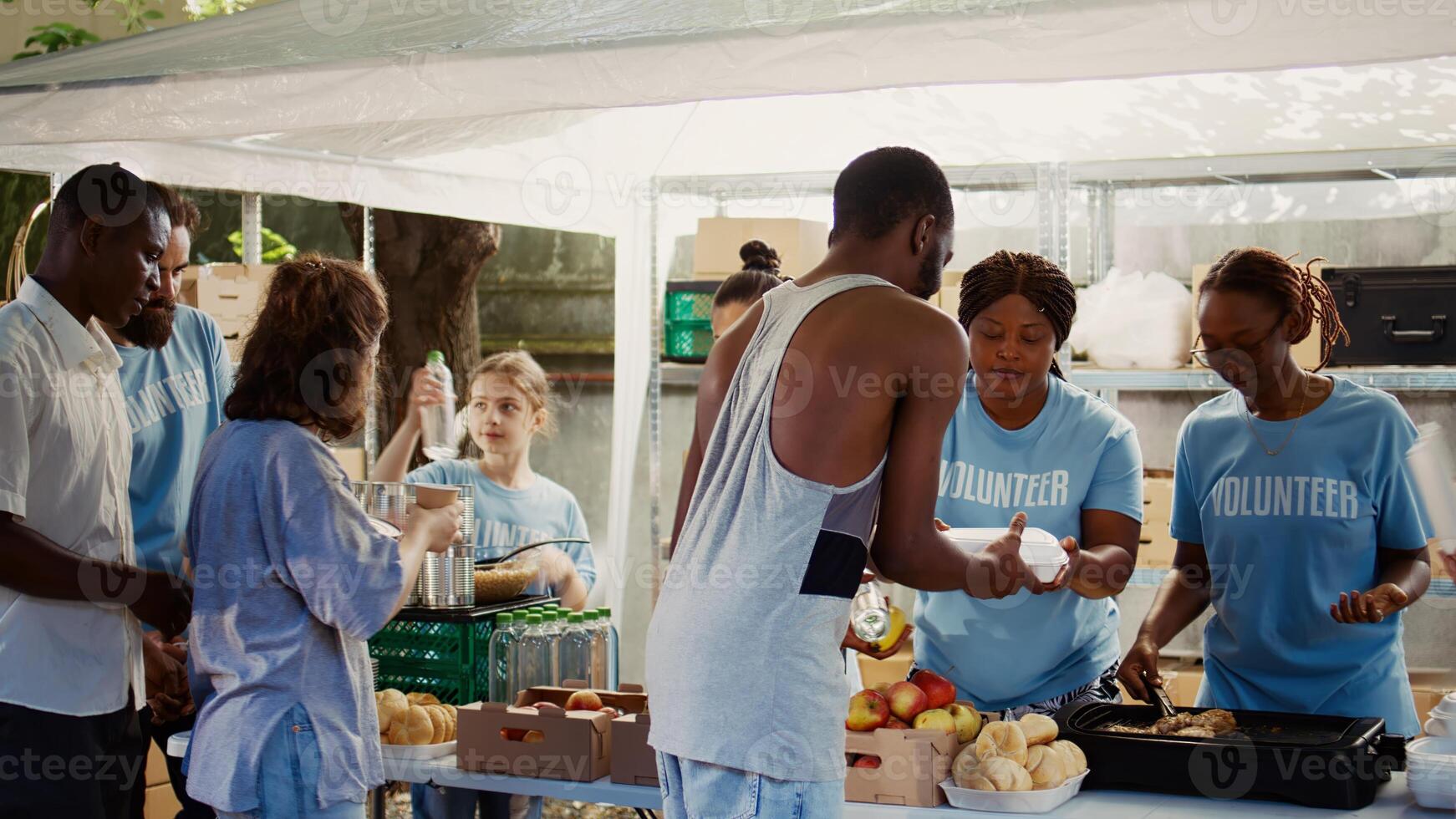 Volunteers extending a helping hand by providing food assistance to homeless people. Voluntary individuals combating hunger and poverty by supporting the poor, needy and less fortunate at food drive. photo