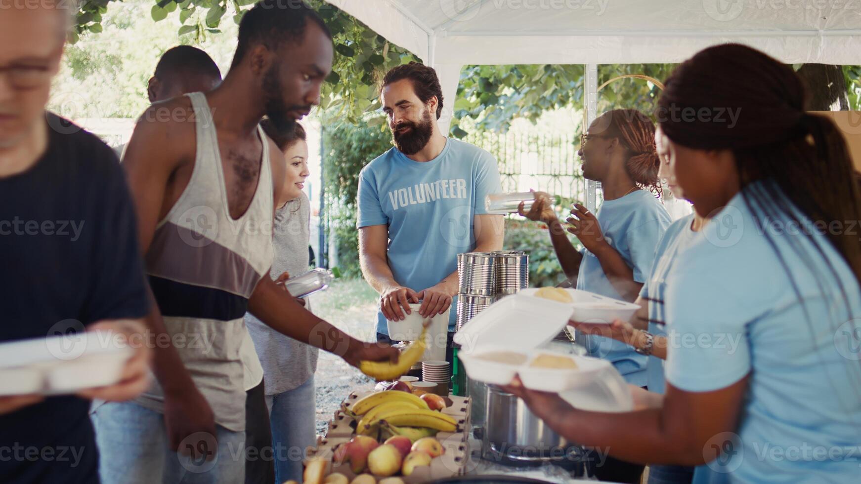 Voluntary individuals selflessly distribute free food to the needy, showing compassion and support in humanitarian charity event. Friendly volunteers offering hot meals and nourishments to the poor. photo