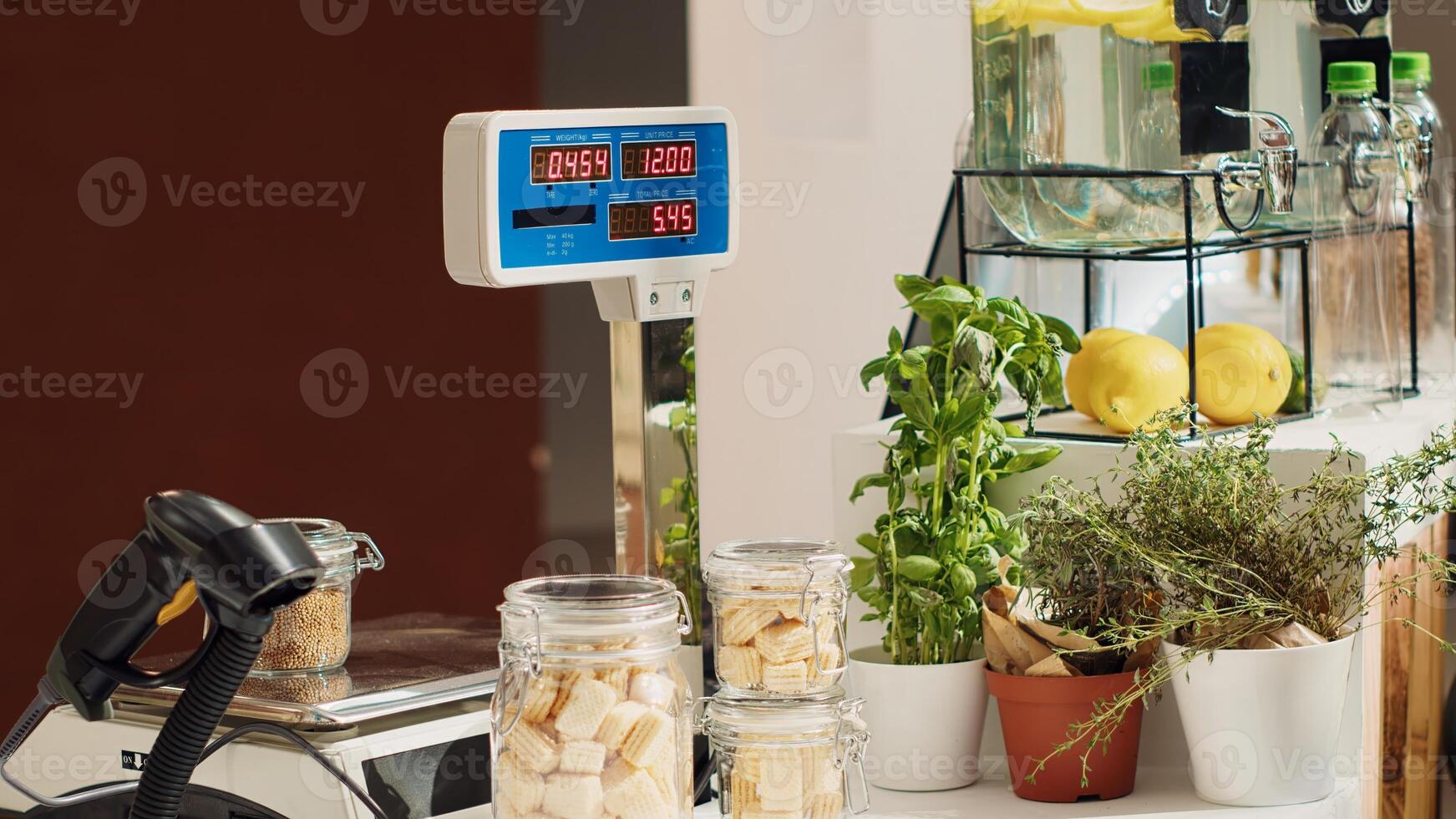 Close up of electronic scale in eco friendly zero waste supermarket next to organic produce. Panning shot of weighing machine in local neighborhood shop used for bulk products photo