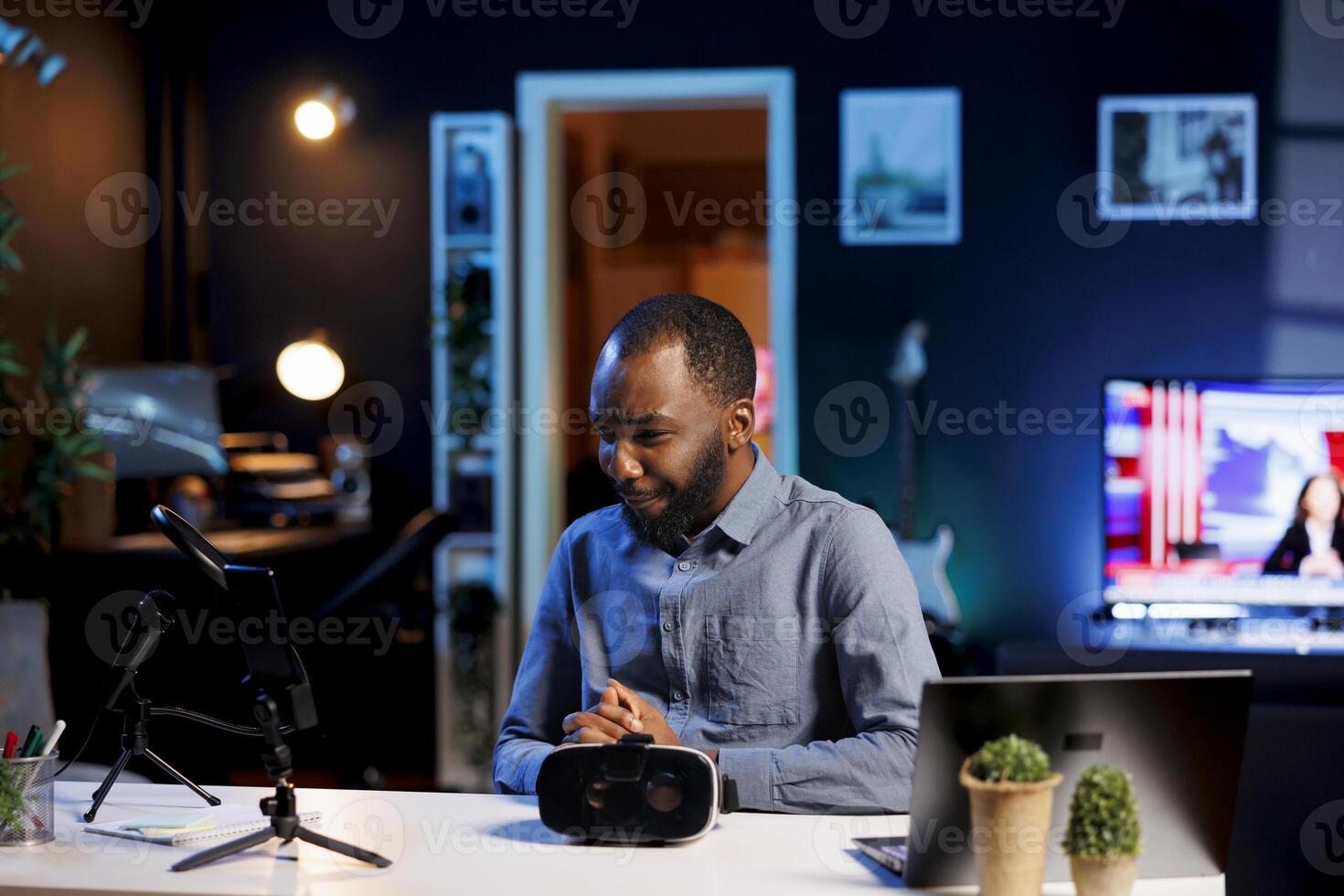 Tech content creator filming technology review of newly launched VR glasses, trying them on his head and presenting specifications to audience. Internet star checking out virtual reality device photo