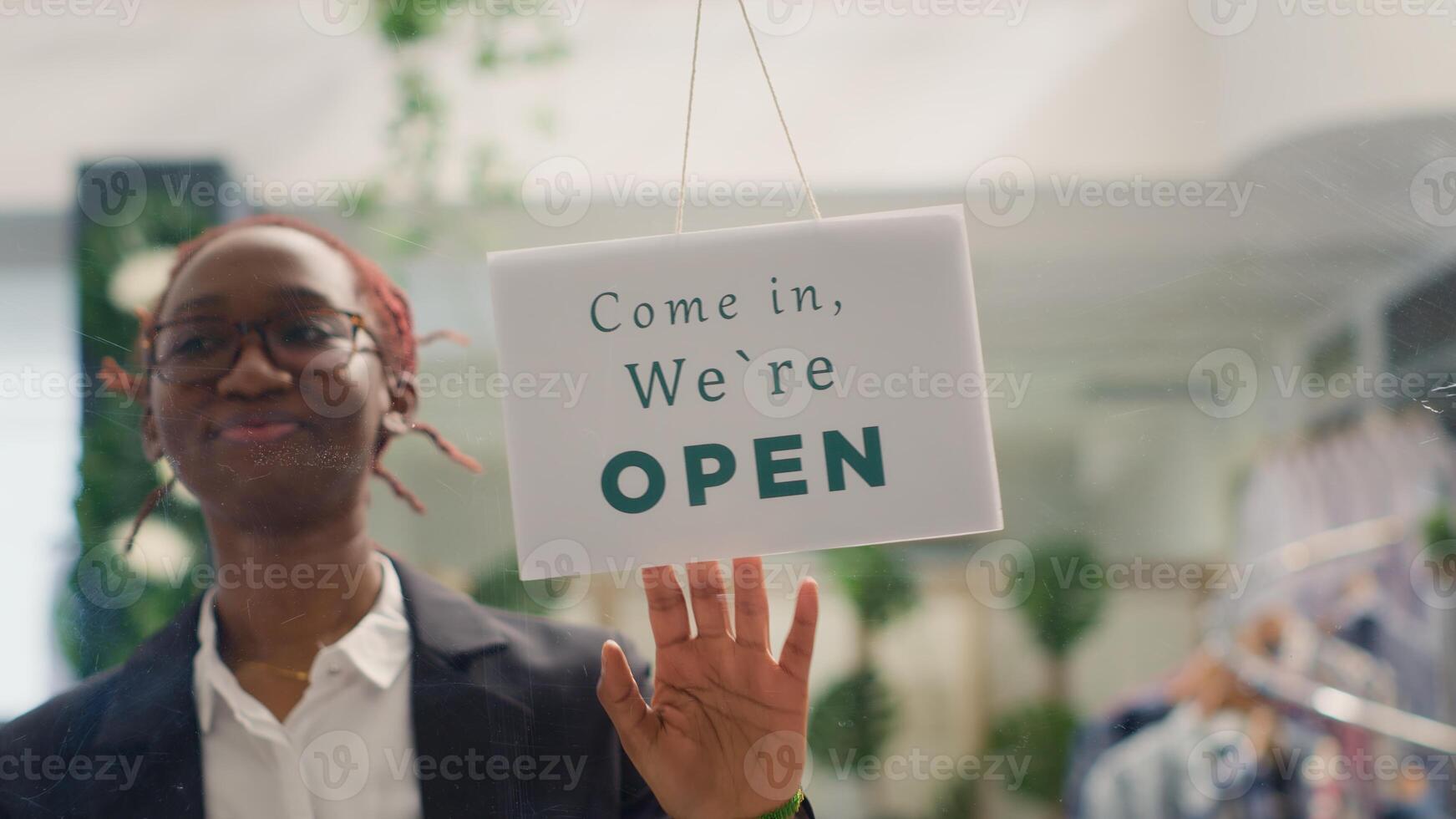 Worker finally reopening store after restocking elegant high end fashion boutique. Woman turning closed sign from clothing store door after adding stylish garments from new collection photo