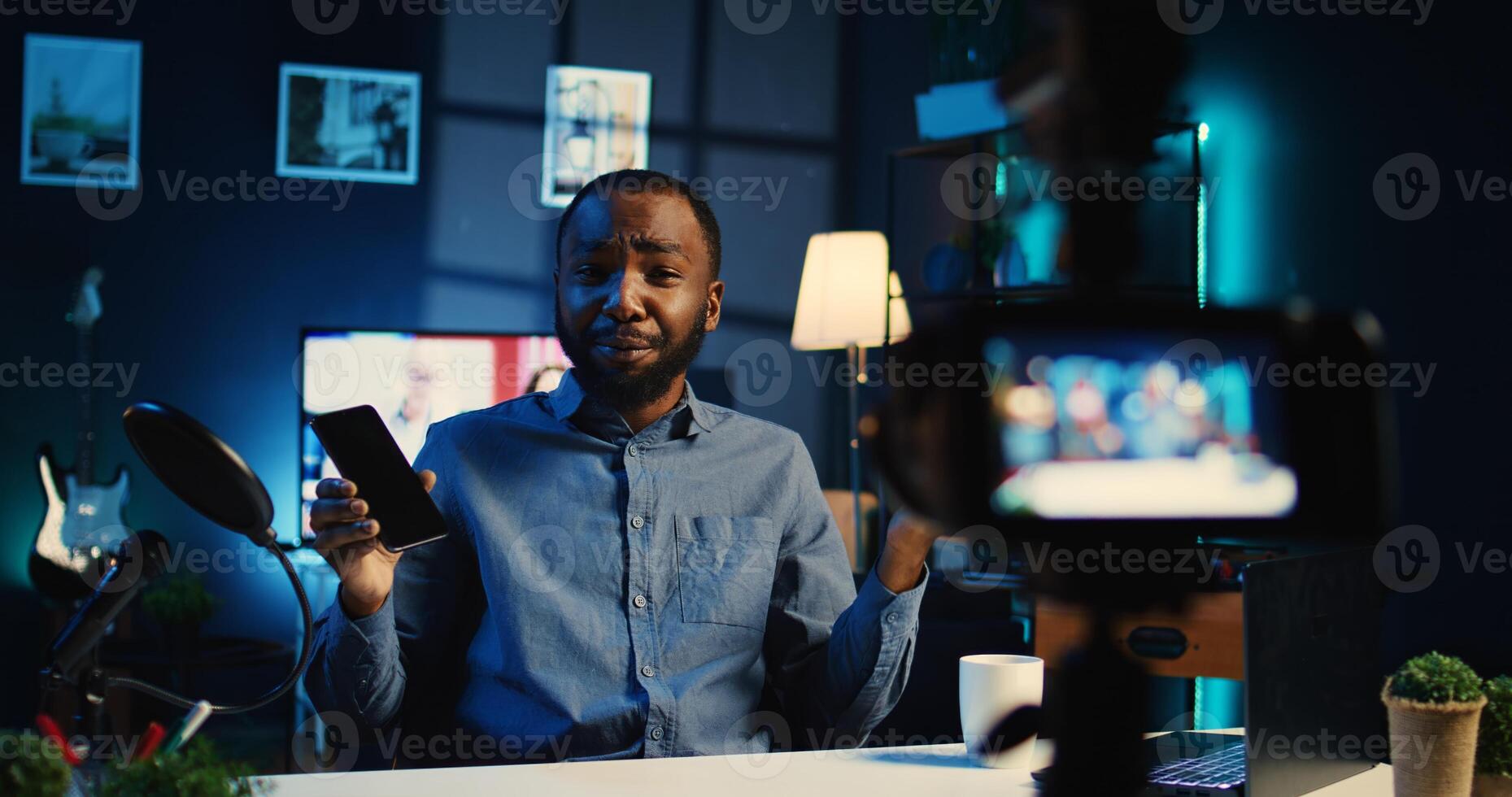 Media star sponsored by tech brand to film review of their newly released smartphone. Influencer showing phone recommendation to fanbase doing research before purchase, handheld camera shot photo