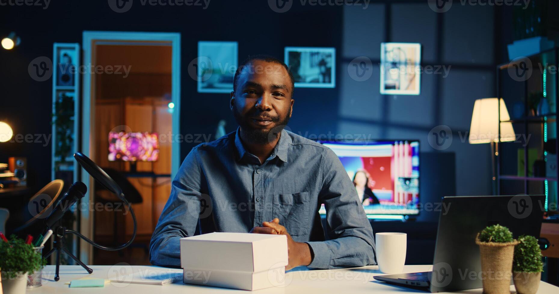 Content creator filming review of newly released smartphone, unpacking it and presenting specs to audience. Influencer showing phone recommendation to subscribers doing research before buying photo