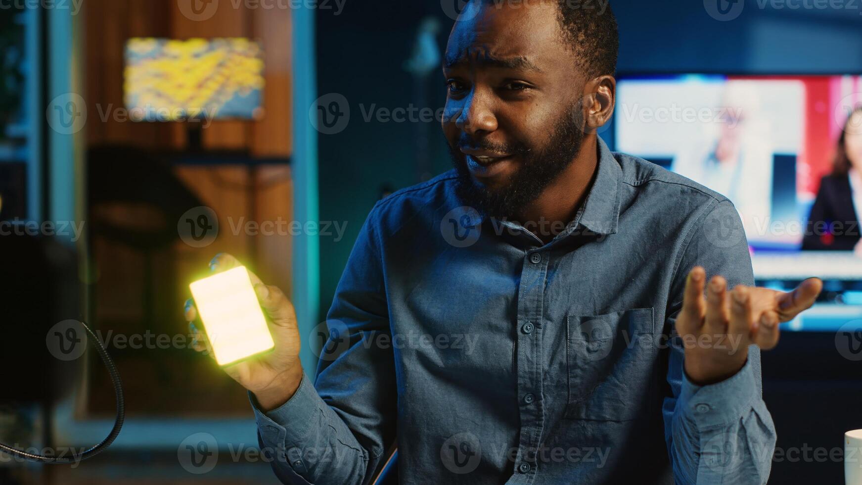 BIPOC tech content creator filming technology review of mini RGB lights device illuminating in different colors. Internet star showing helpful production tool to subscribers photo