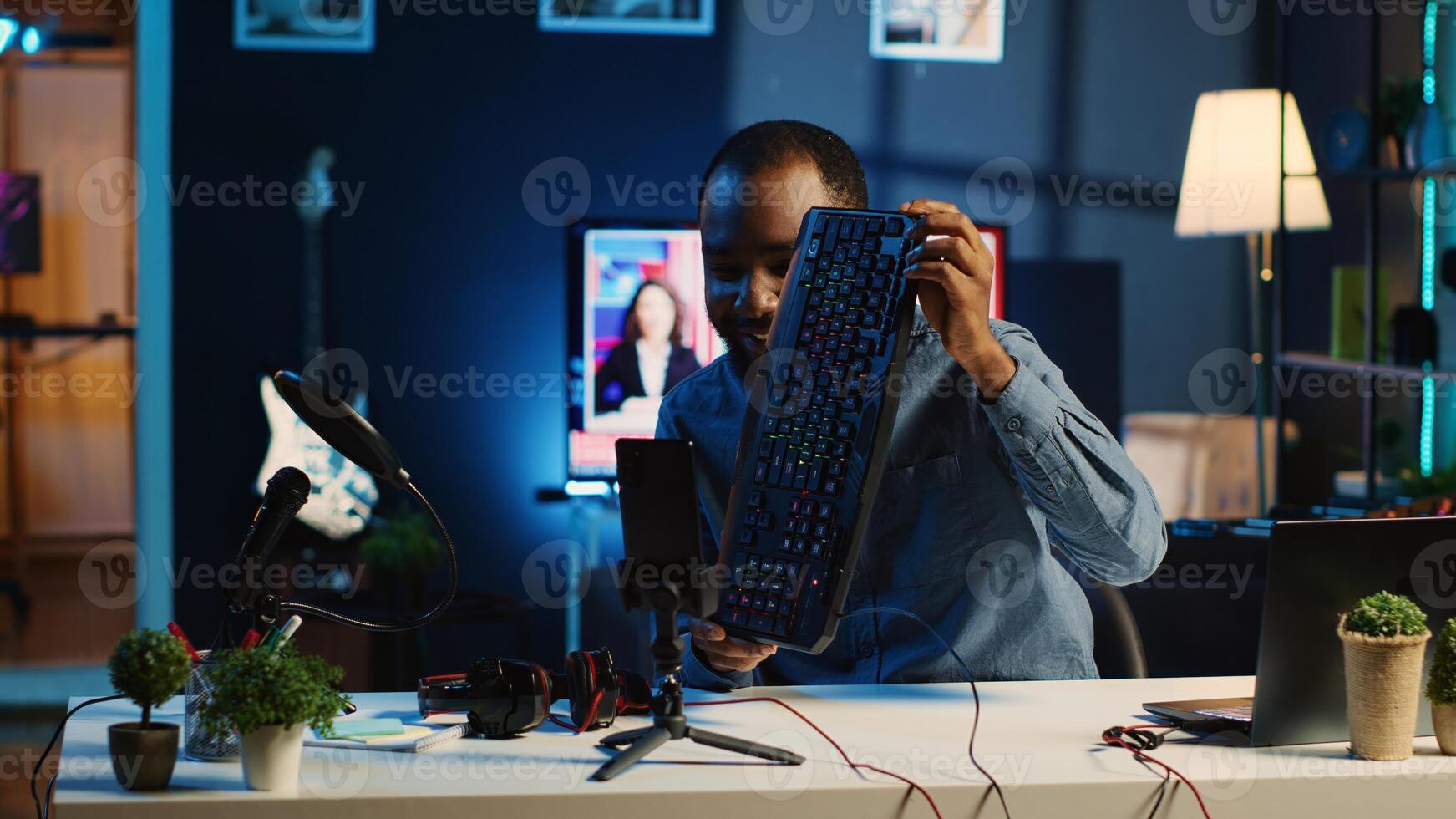 African american technology internet star filming review of newly released USB wired keyboard, mouse and headphones, giving audience feedback about comfort experience, doing endorsement photo