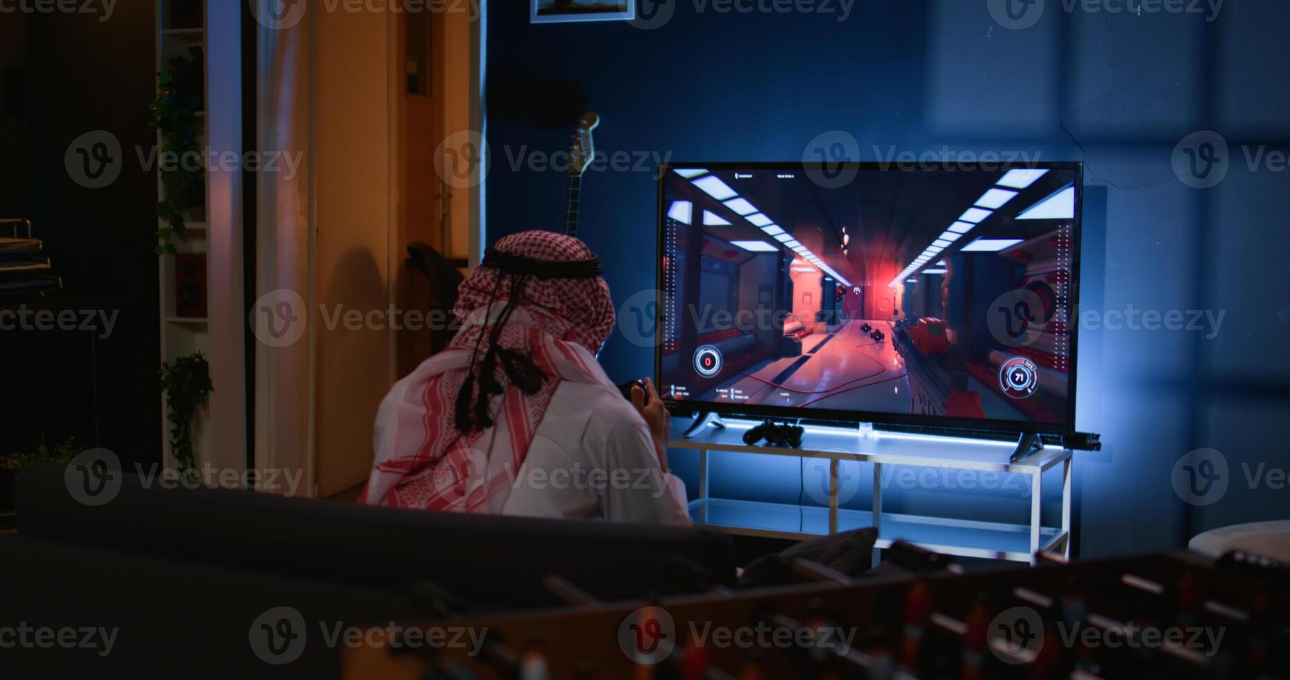 Middle Eastern gamer feeling gutted after losing singleplayer action videogame level, being outsmarted by enemies. Muslim man at home frustrated after seeing game over screen photo
