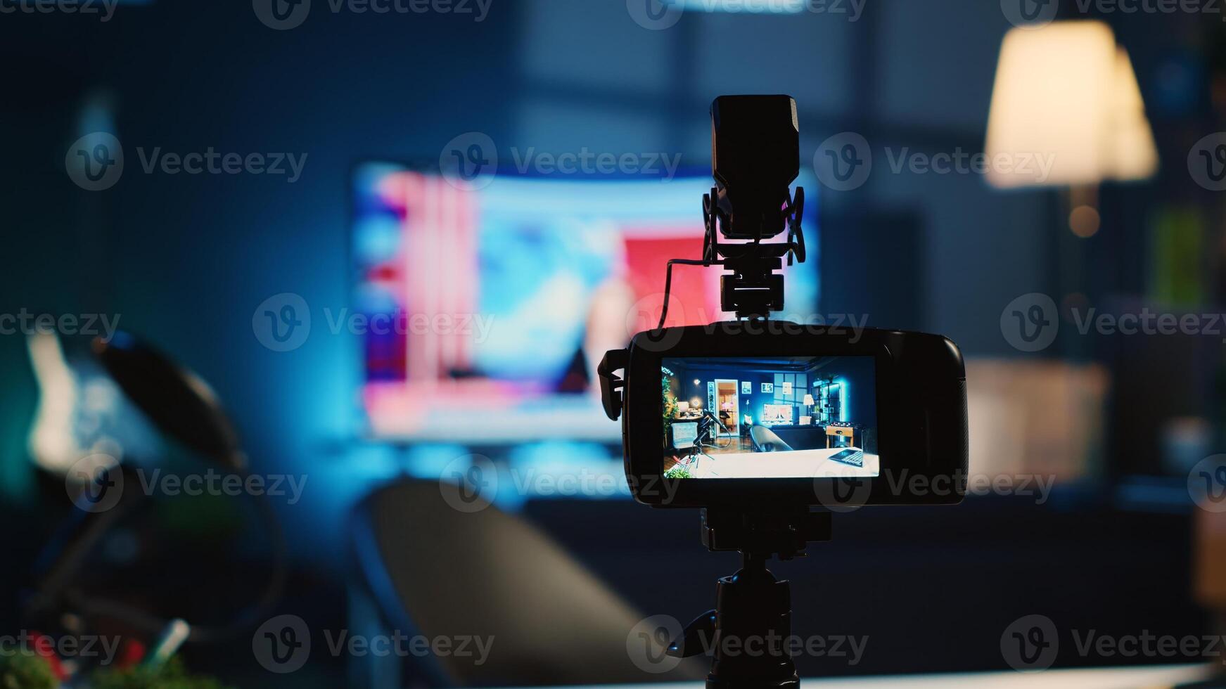 Extreme close up shot of camera on tripod used by media star in dimly lit apartment studio to film for online platforms. Recording device in empty room used by content creator to capture footage photo