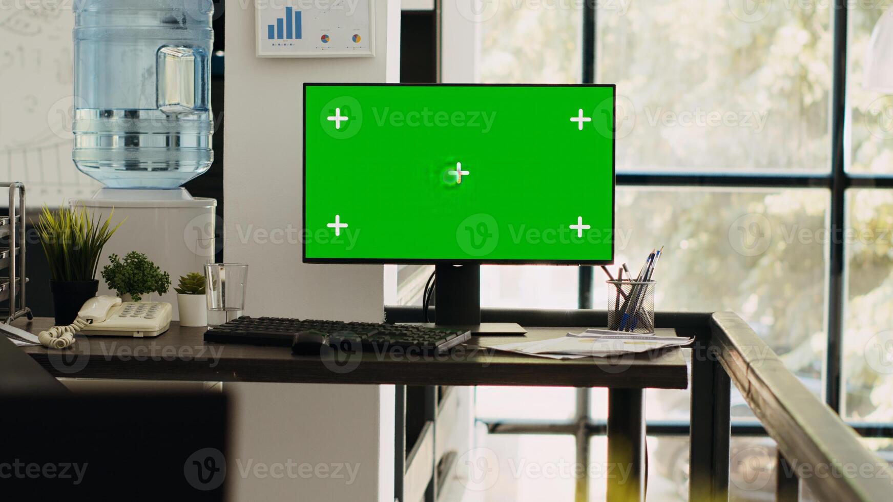 Modern coworking space with monitor showing isolated greenscreen, blank chromakey screen on computer. Empty office desk with pc running mockup template, copyspace layout on desktop. photo