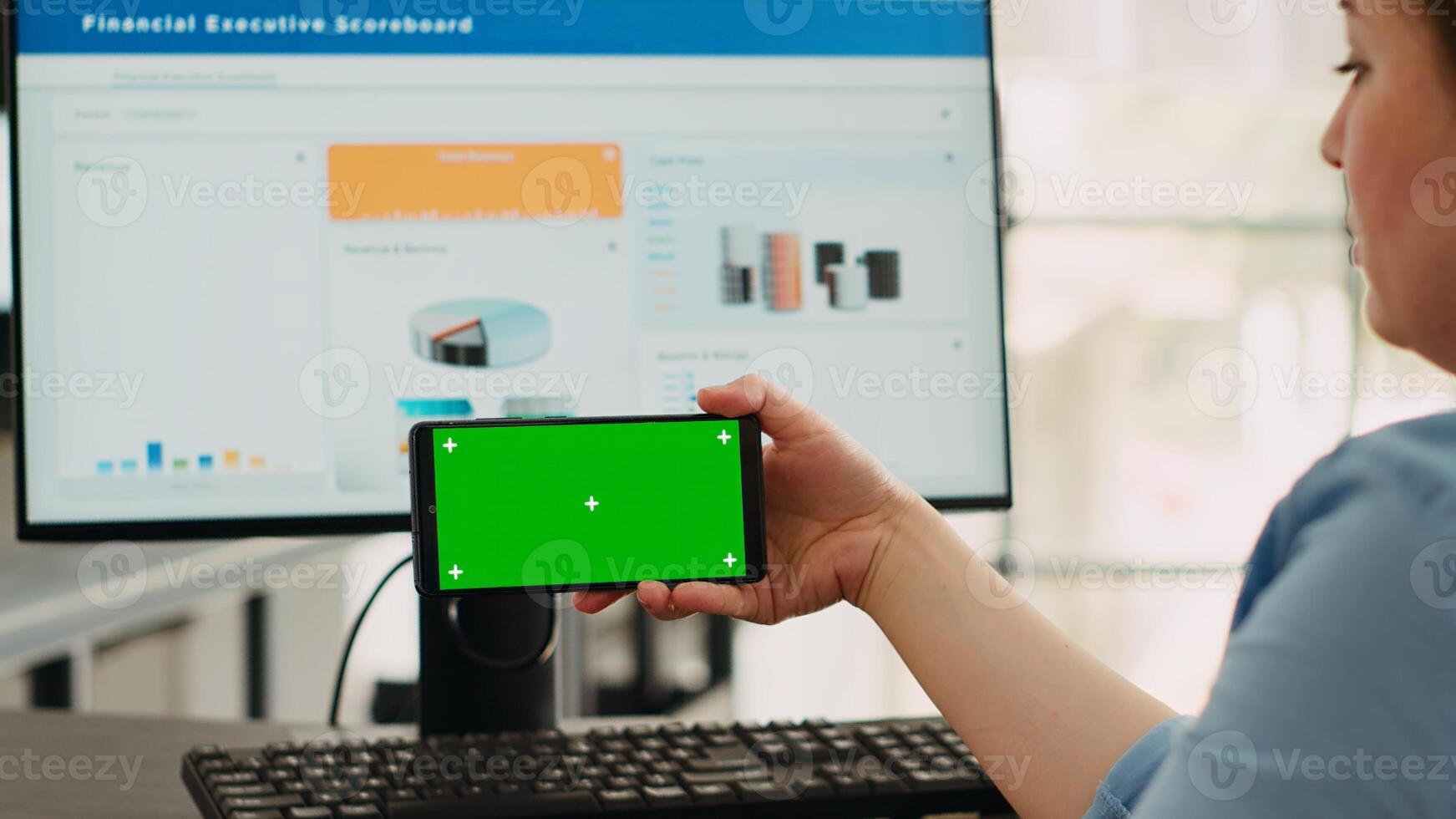 Business operator focusing on blank mockup screen with copyspace overlay while using isolated greenscreen on mobile phone. Employee examining smartphone display with chromakey template. photo
