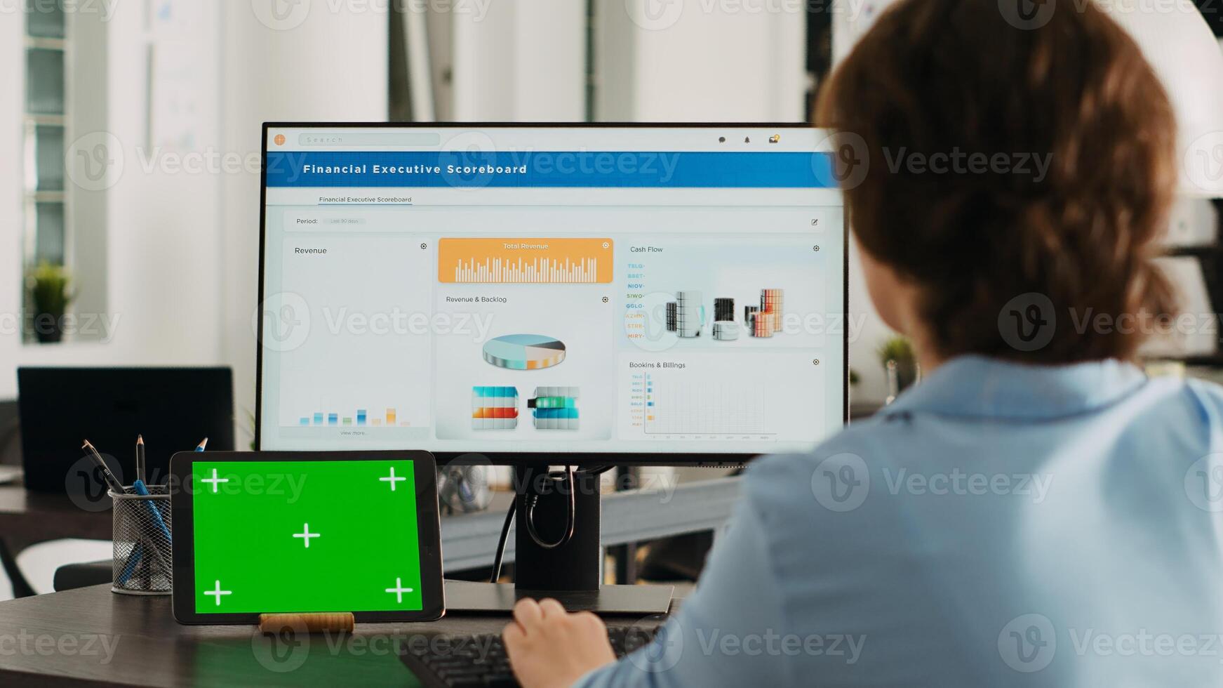 Office worker checks greenscreen display on tablet, working on business operations with isolated copyspace template and analyzing data on computer at desk. Having gadget with mockup. photo