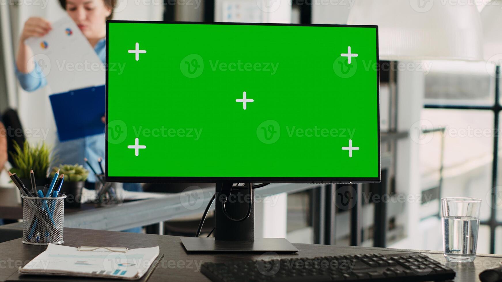 Greenscreen on computer desktop at empty workstation. PC with isolated mockup template and chromakey app running in open floor plan agency workplace, blank display copyspace technology. photo