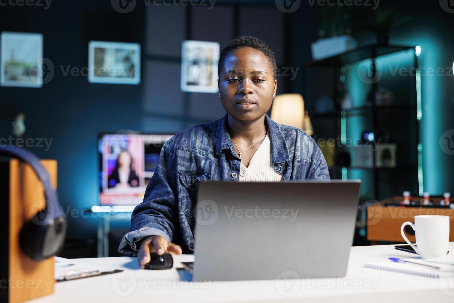 Young african american freelancer working at home on her digital laptop, reviewing documents. Black woman sitting at desk, using personal computer, checking and answering emails. photo