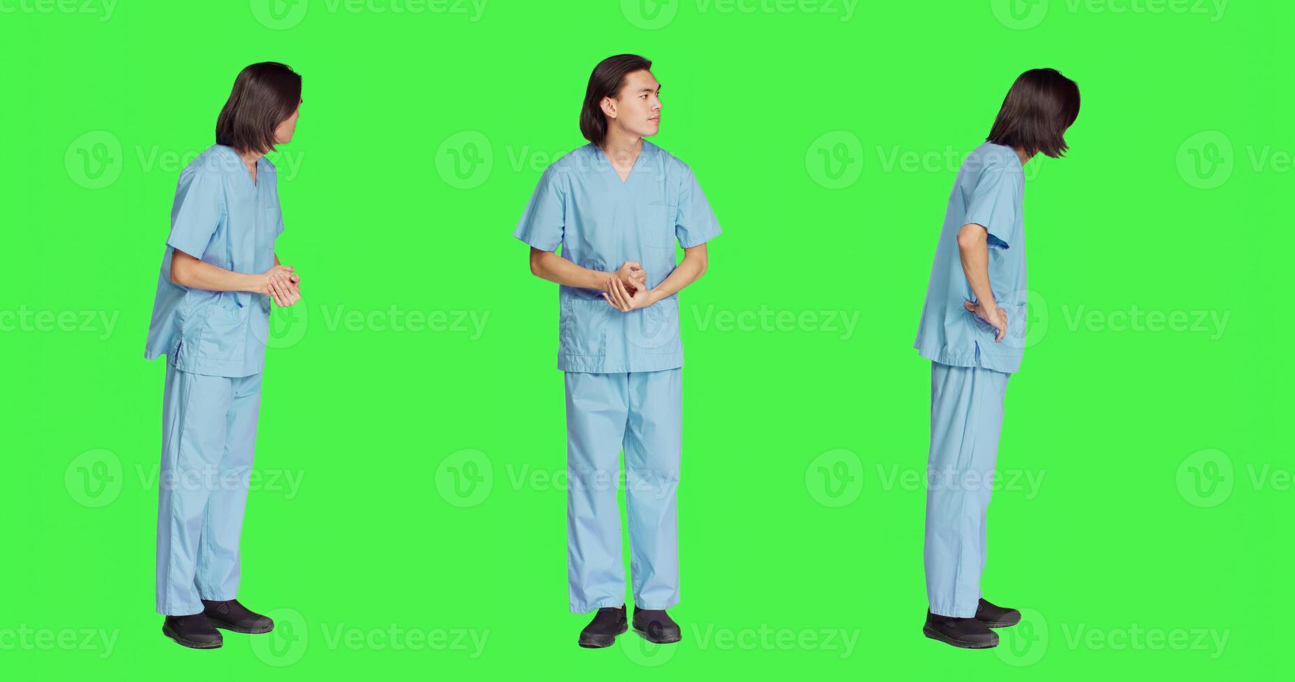 Over greenscreen wall, healthcare worker awaits for event, dressed in hospital protective outfit and being anxious. Man with medical expertise and natural abilities stands in studio. photo