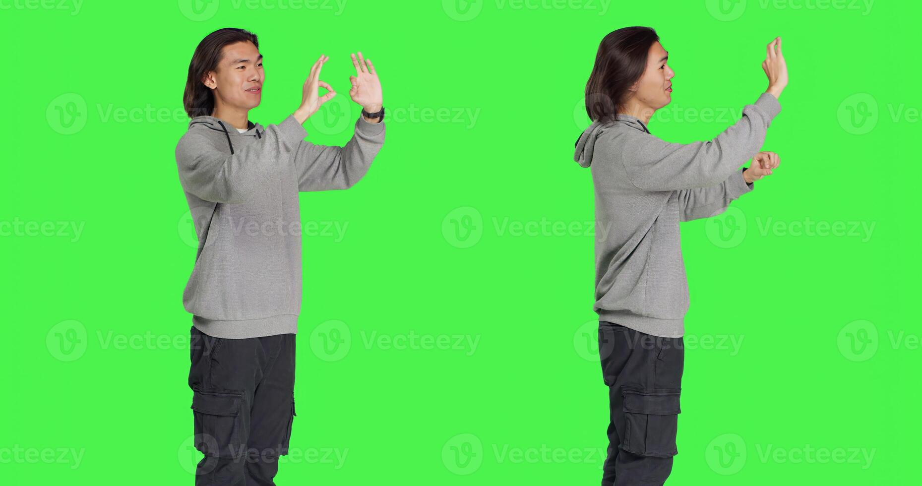 Young model showing okay symbol in studio, acting pleased and happy with something over greenscreen backdrop. Asian man feeling positive and shows agreement or gives his approval. photo