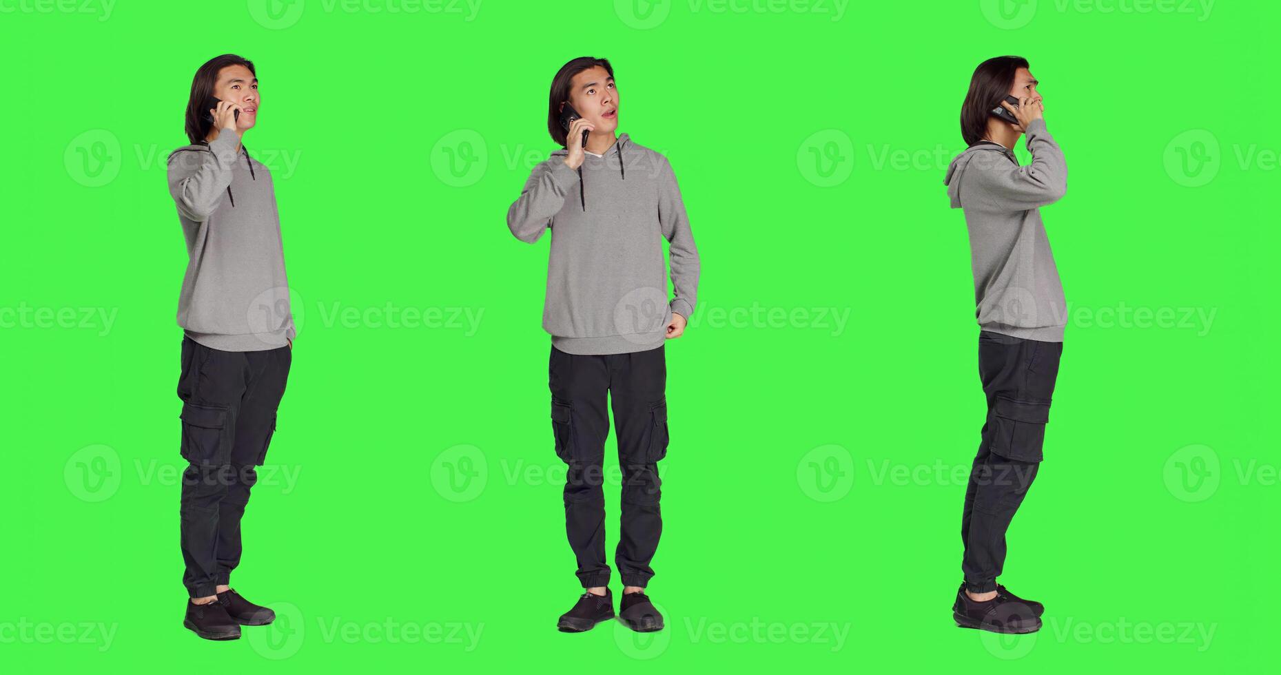 Modern guy talking on smartphone call over full body greenscreen, using telephone line to talk to his colleagues in studio. Young person answering call to have remote discussion. photo