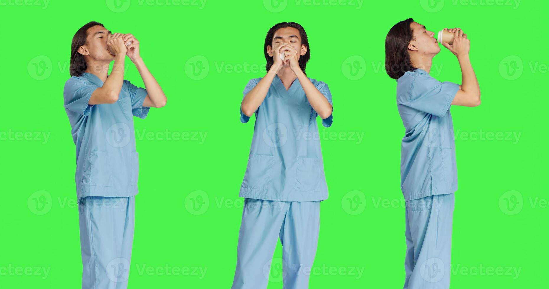 Asian specialist enjoying coffee cup against greenscreen backdrop, male nurse with healthcare expertise drinking hot caffeine refreshment in studio. Medical assistant with uniform. photo