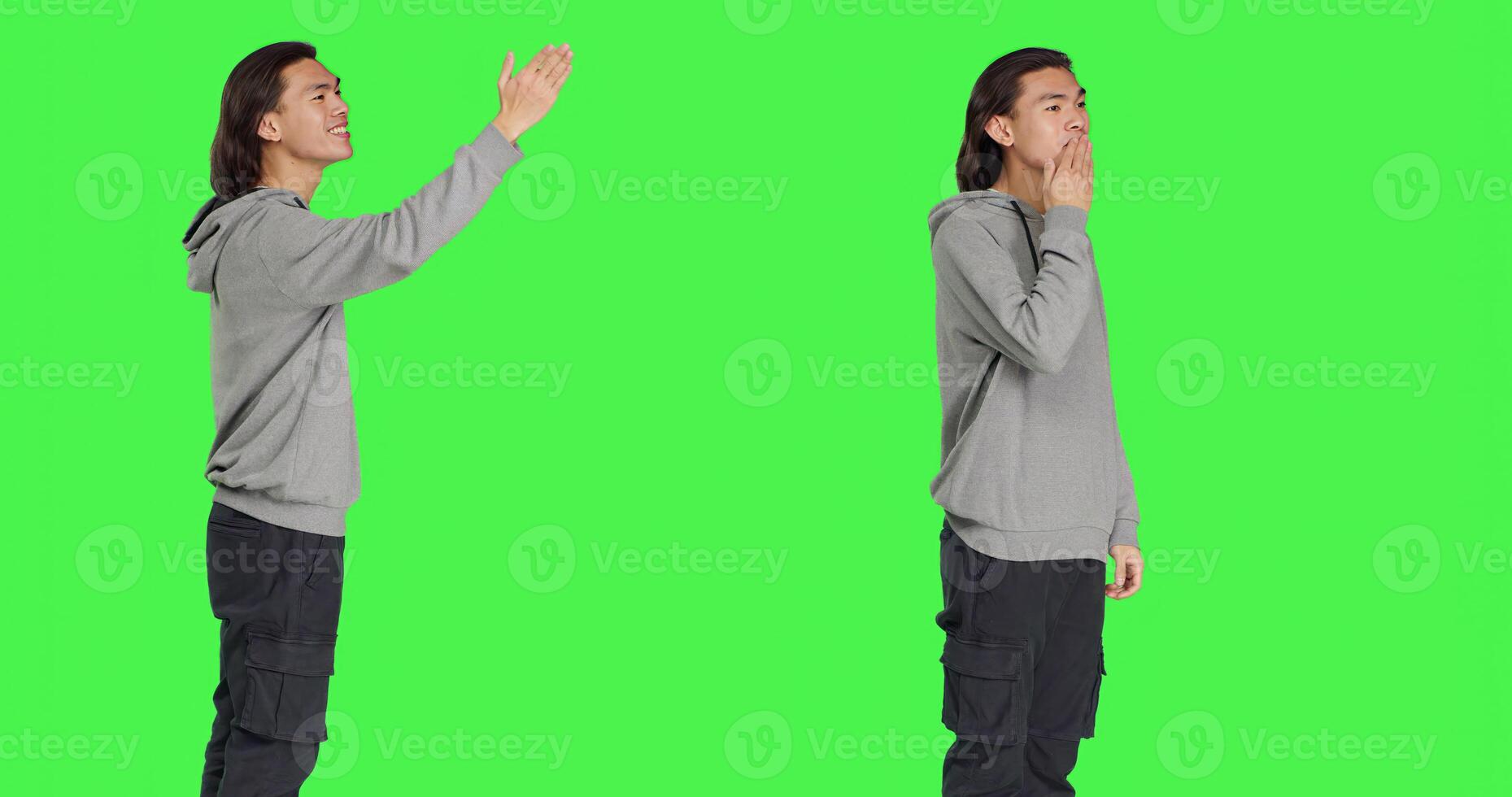Asian guy sending air kisses on camera, acting romantic and cute standing against greenscreen background studio. Young adult feeling confident and joyful showing true honest emotions. photo