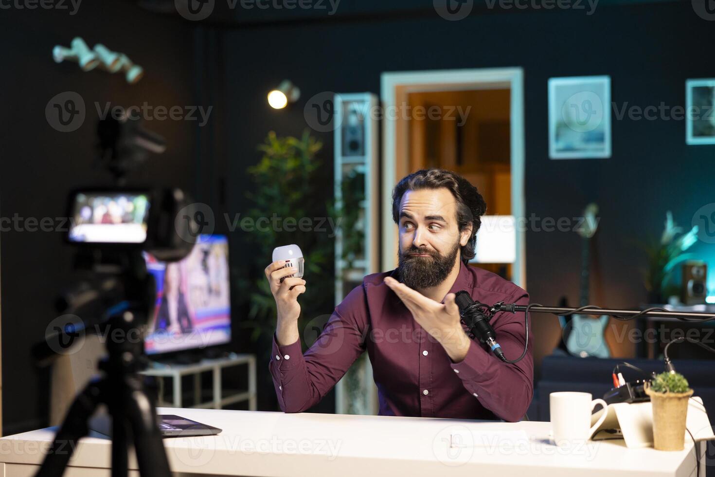 Tech expert looking at defective smart light bulb, trying to repair it while filming. Internet star hosting technology show, fixing broken IoT home automation product in neon lit studio photo