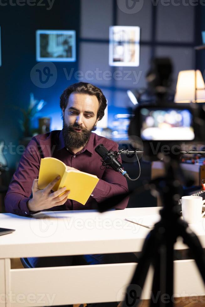 Experienced voice actor in studio working on audiobook recording production, reading from book, capturing sound with professional mic and filming with high quality equipment camera photo