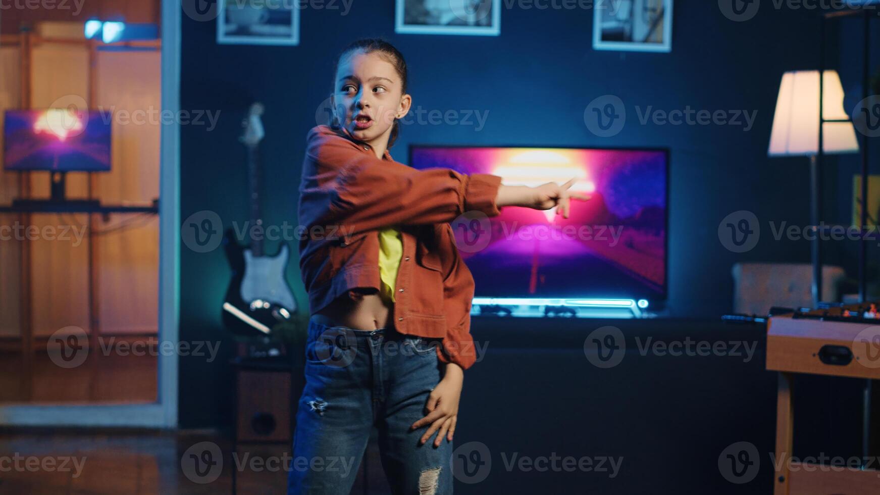 Excited youngster doing viral dance social media content while listening to popular hit song. Joyful kid recording dancing for her internet audience on latest viral music photo