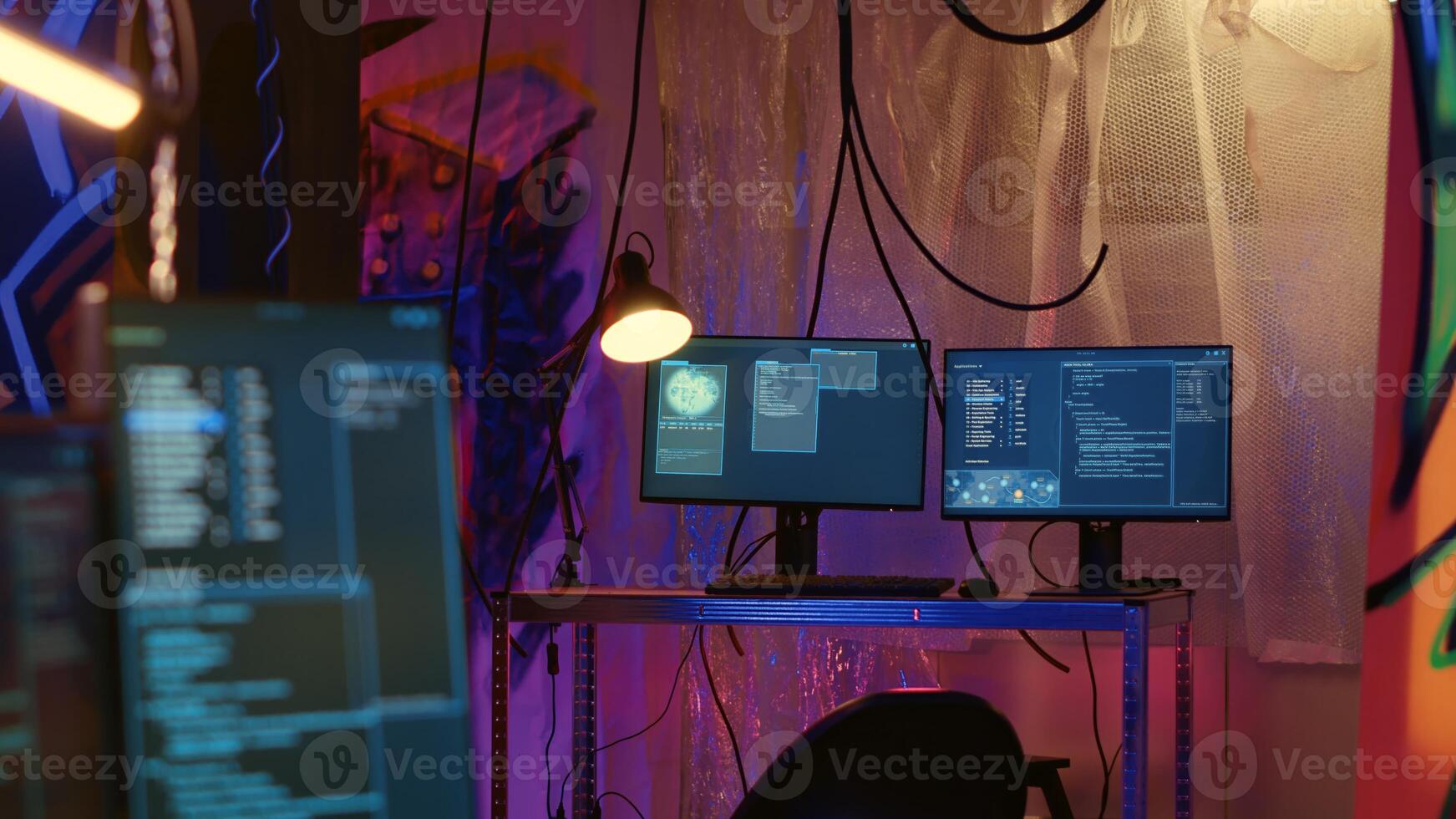 Software interface on computer screen showing programming code used for making malware in empty warehouse with graffiti sprayed on walls. Hacking script running on PC monitors in underground base photo