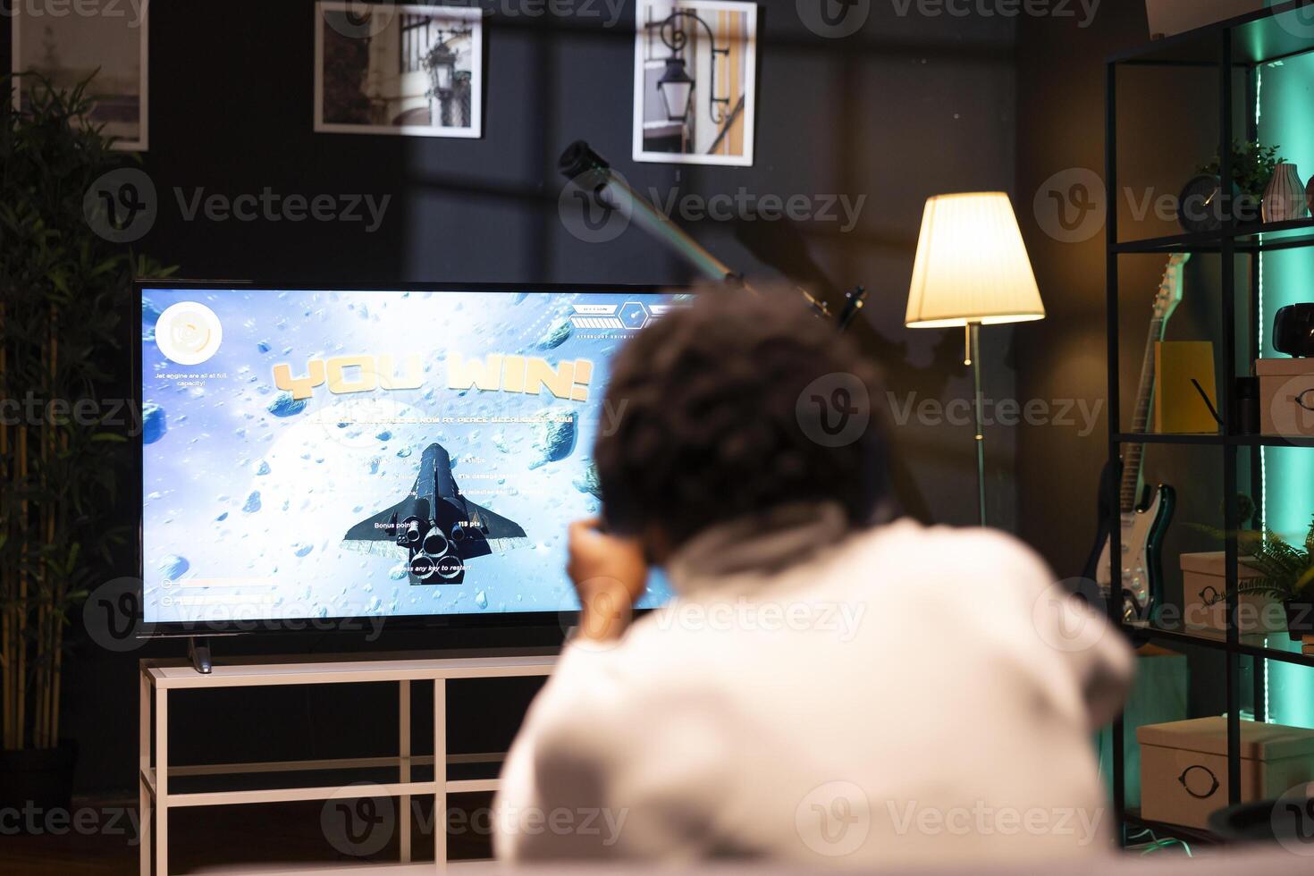 Man playing videogames on gaming console, celebrating victory after defeating all enemies. Gamer excited after winning internet esports game match on smart TV display, rejoicing photo