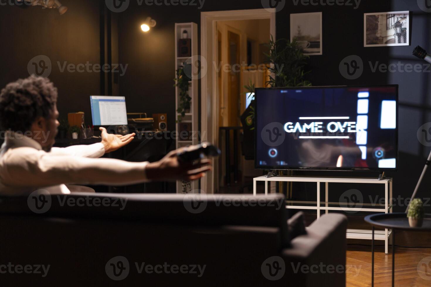 Gamer feeling gutted after losing SF videogame level, screaming at television set in anger. Angry man at home yelling, frustrated after seeing game over screen on smart TV display photo