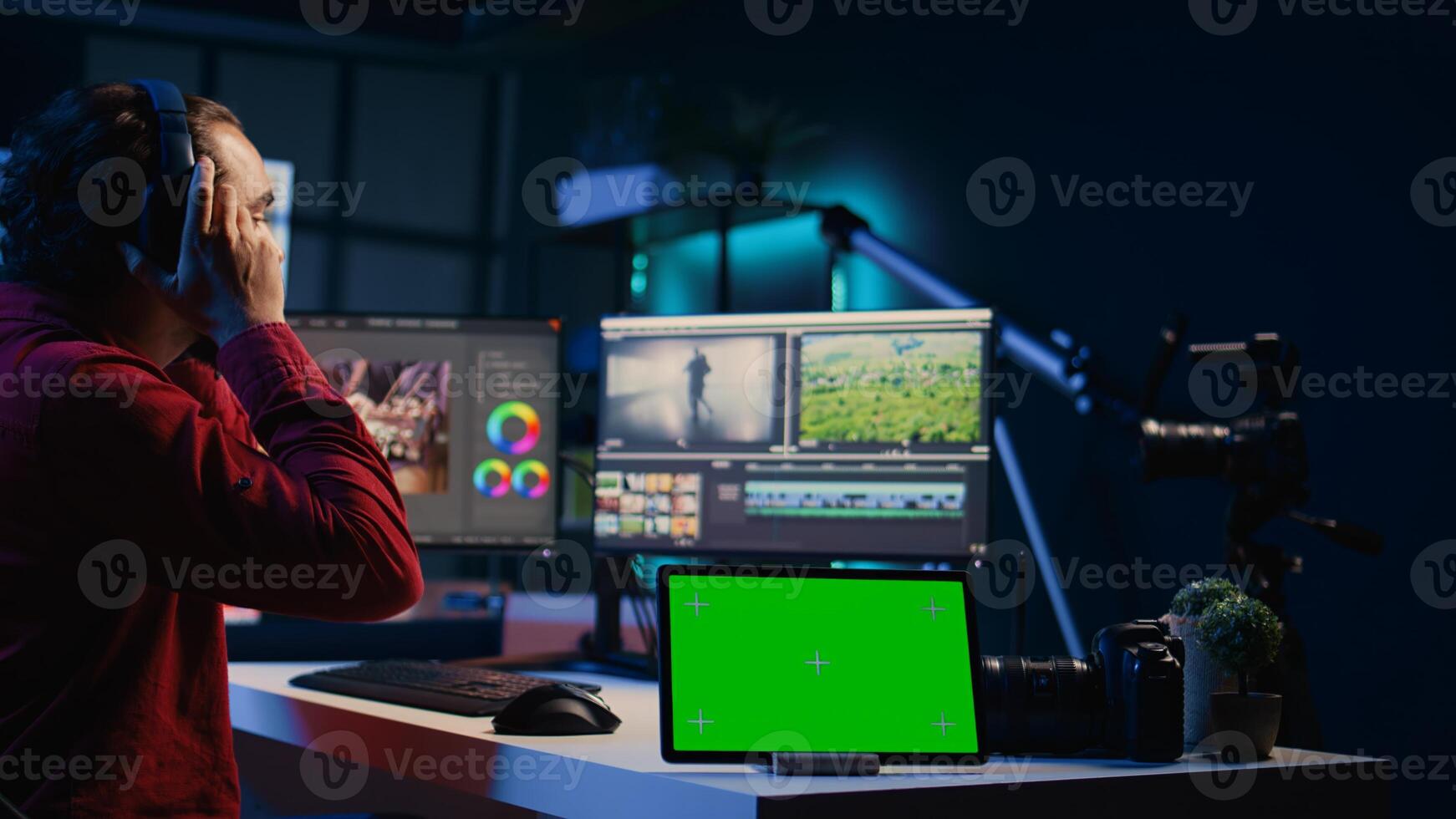Chroma key tablet next to editor using editing software to upgrade footage. Isolated screen device near freelancer videographer finishing project in apartment studio photo